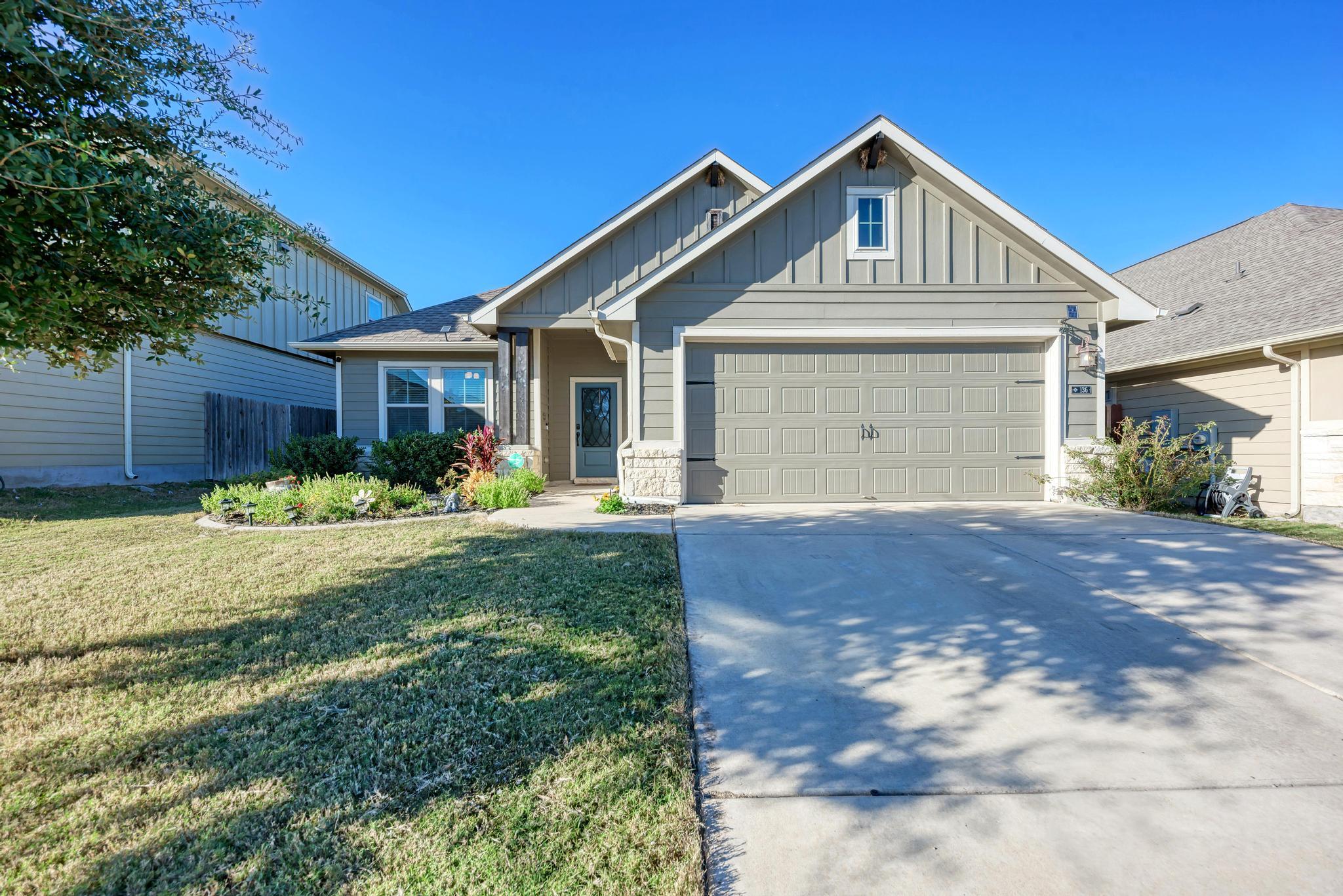 A well-maintained facade with a neat lawn and thr
