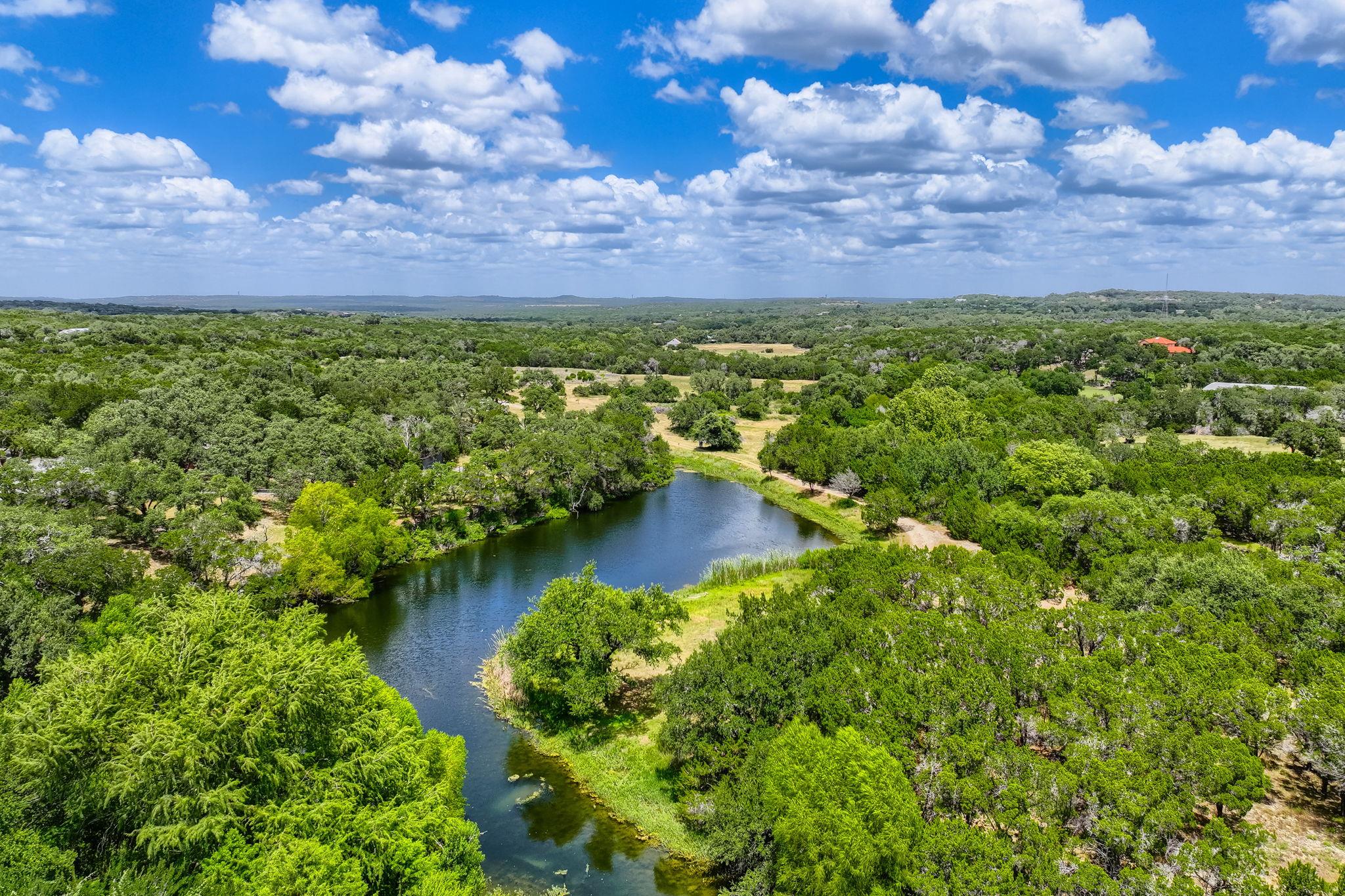 Vast natural landscape featuring a winding pond a