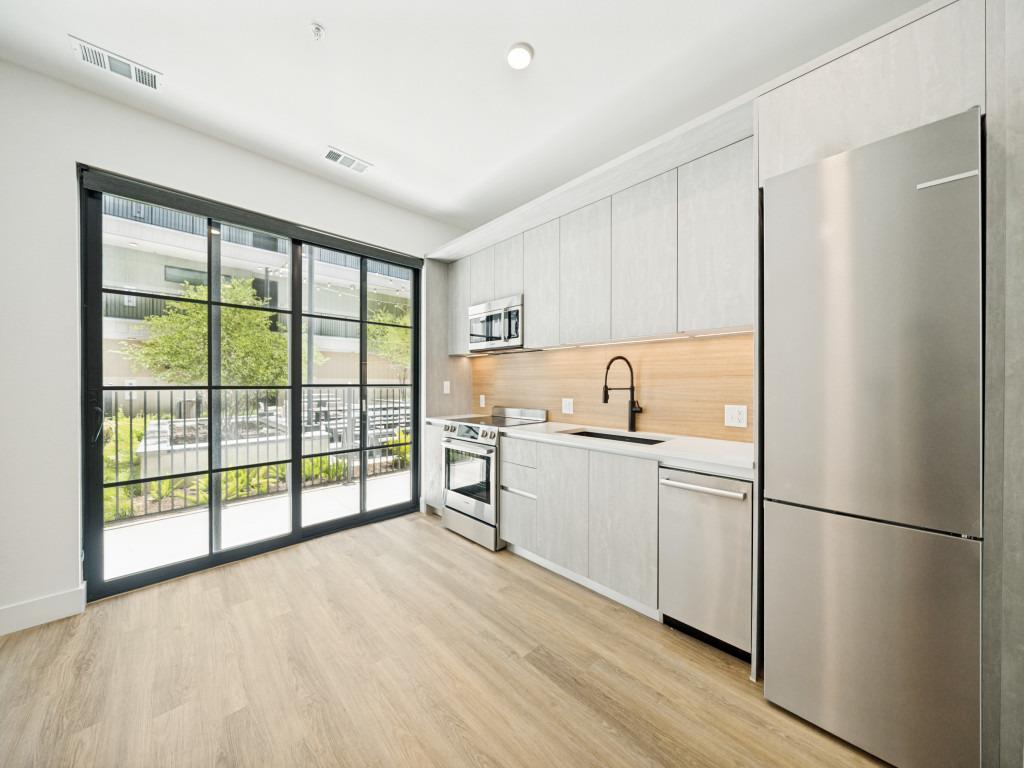 A sleek, contemporary kitchen boasts light wood f
