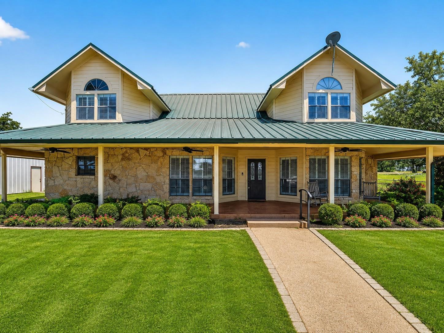 A stone veneer facade and classic metal roof defi