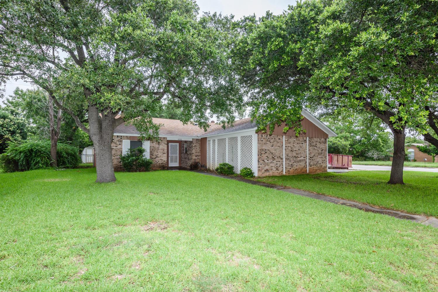 Mature trees shade this charming brick home with 