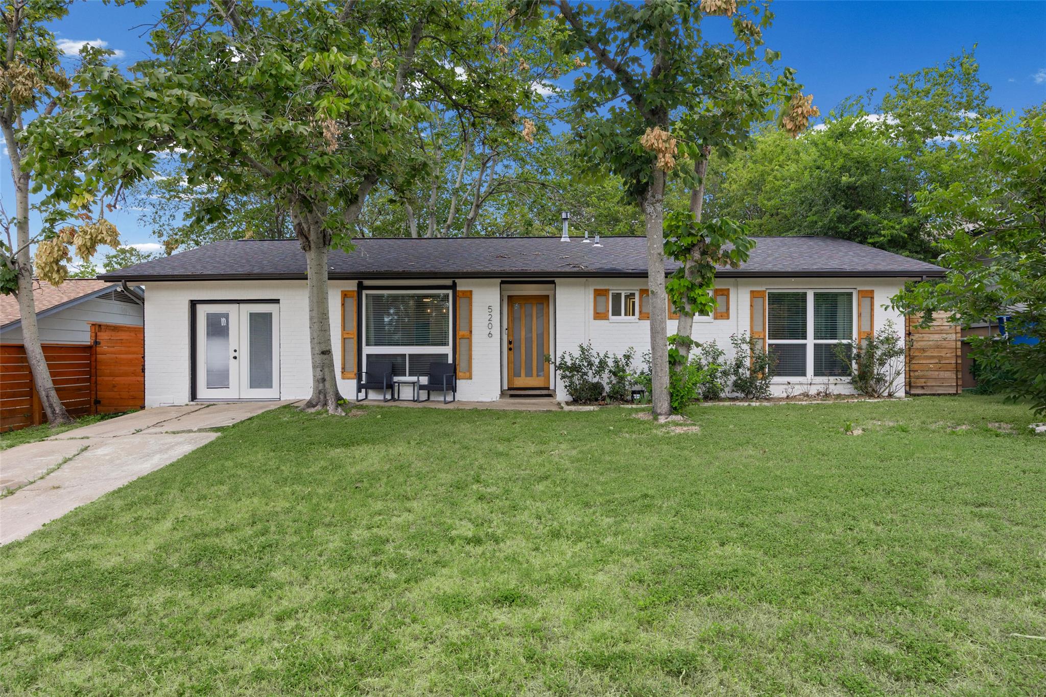 White brick exterior with natural wood accents cr