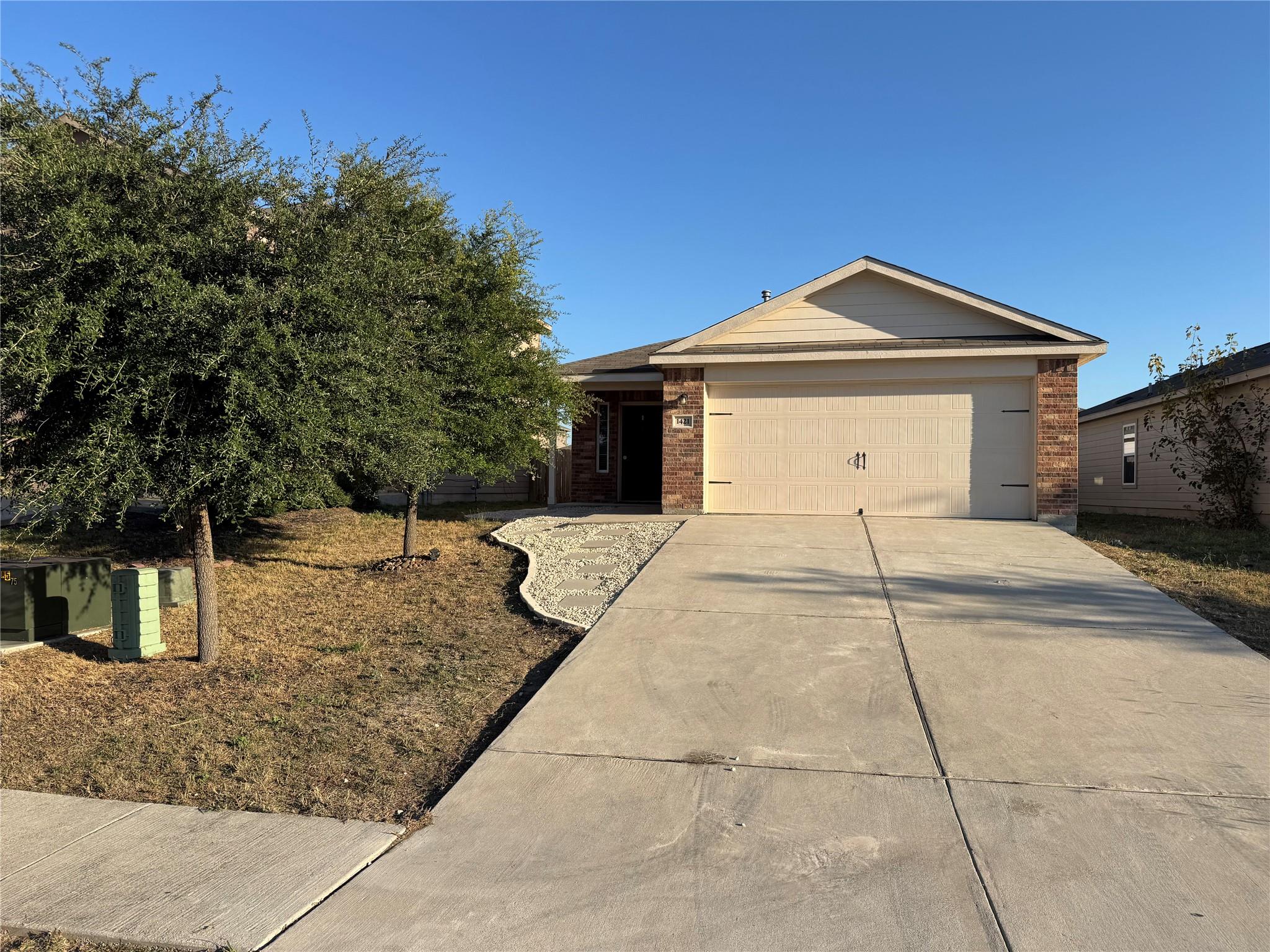A welcoming facade with a concrete driveway leads