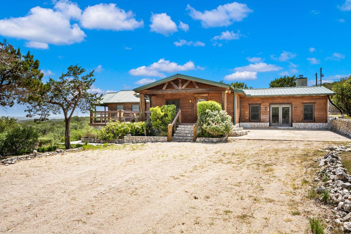 A spacious front yard leads to a charming rustic 