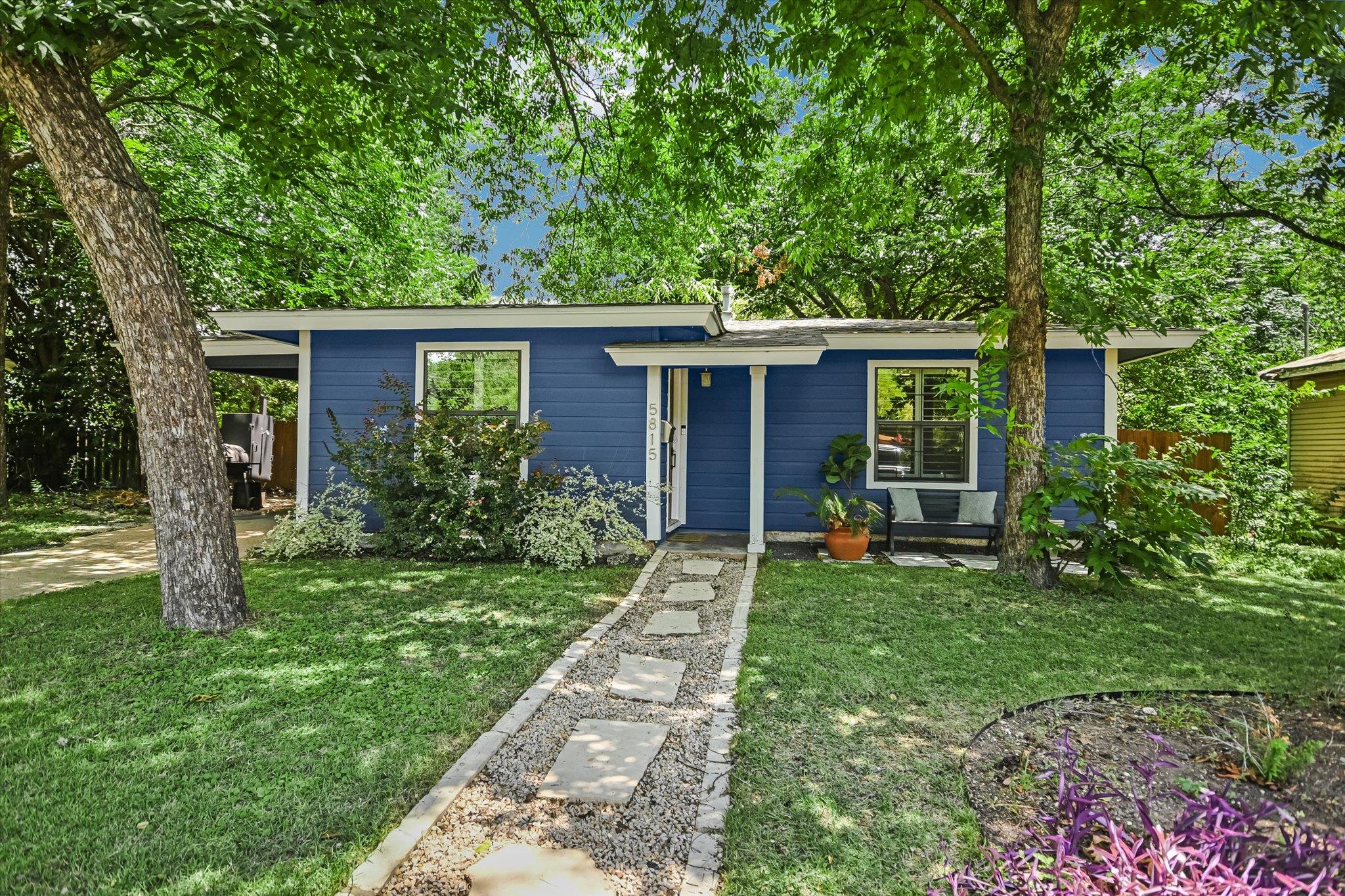 A charming blue residence with verdant landscapin