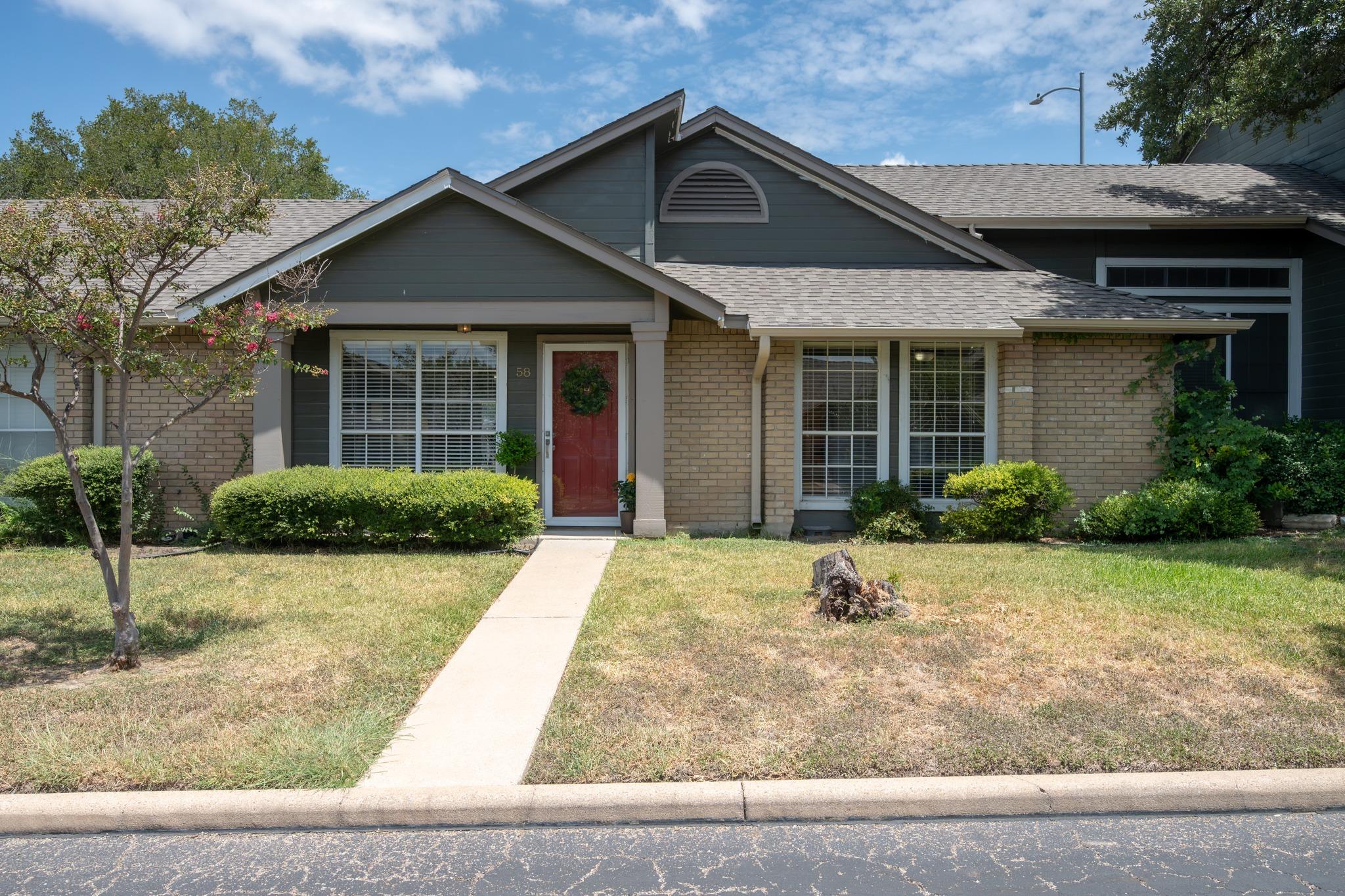 A welcoming brick and siding home presents a neat