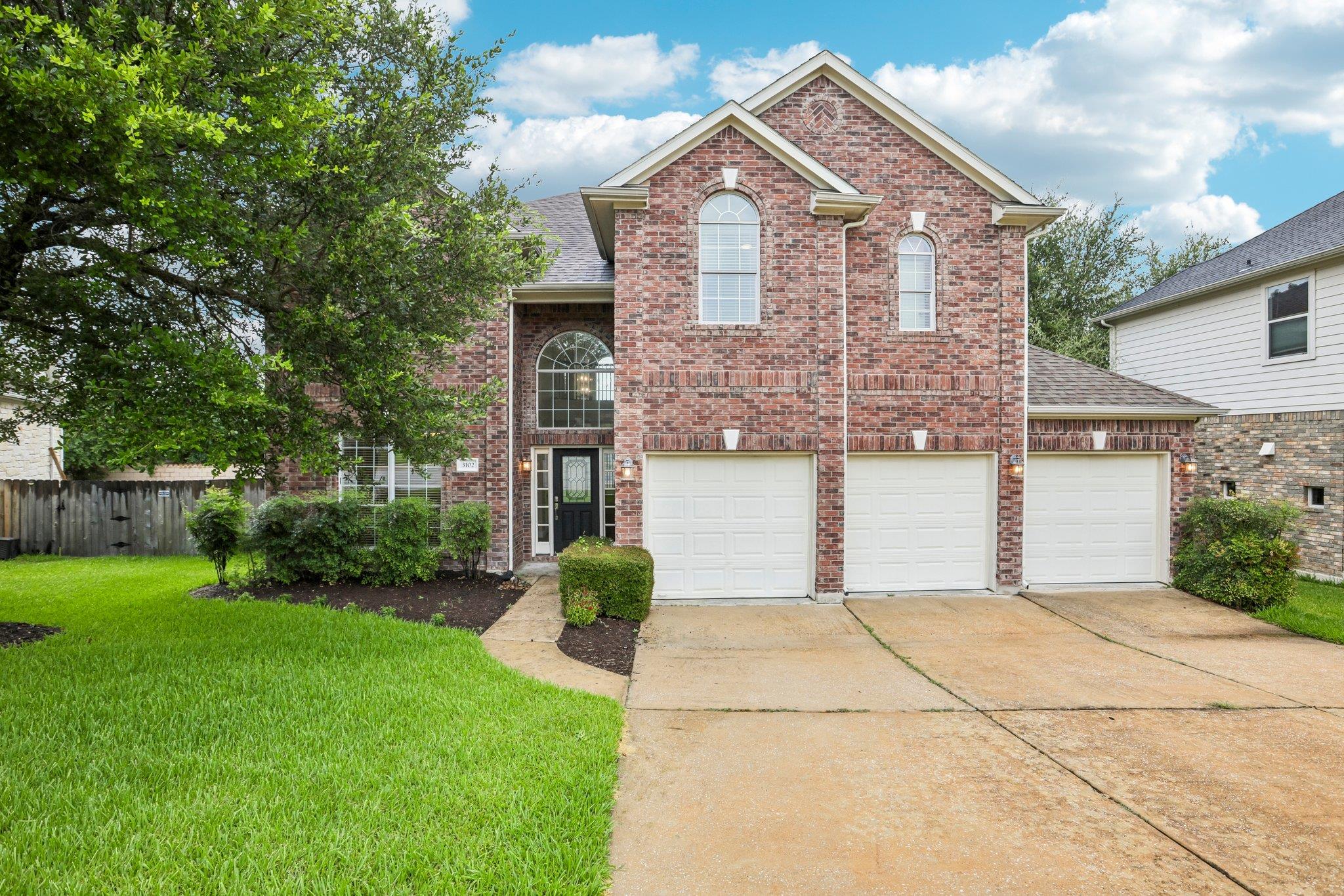 A classic brick facade welcomes with multiple gar