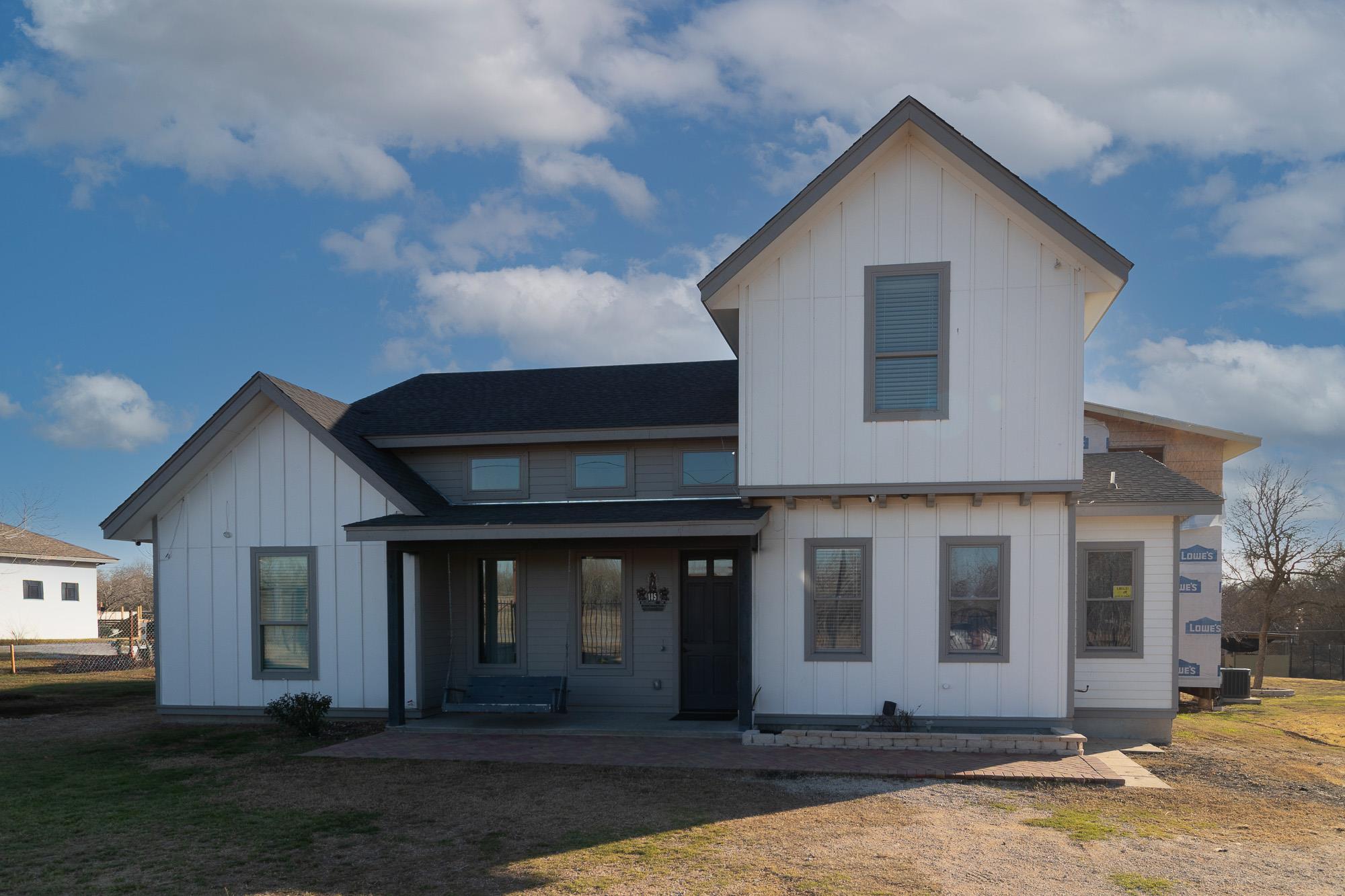 A modern farmhouse-style residence features crisp