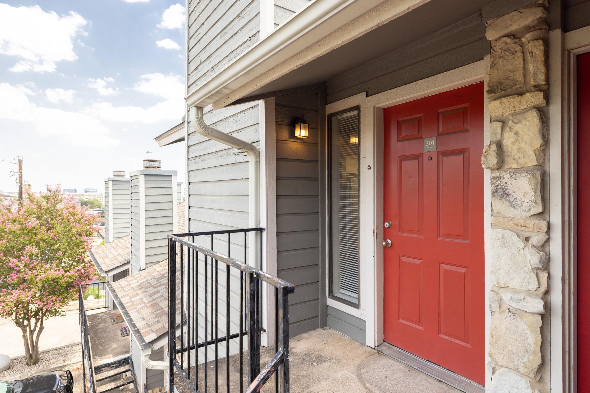 A vibrant red entry door welcomes you to this mul