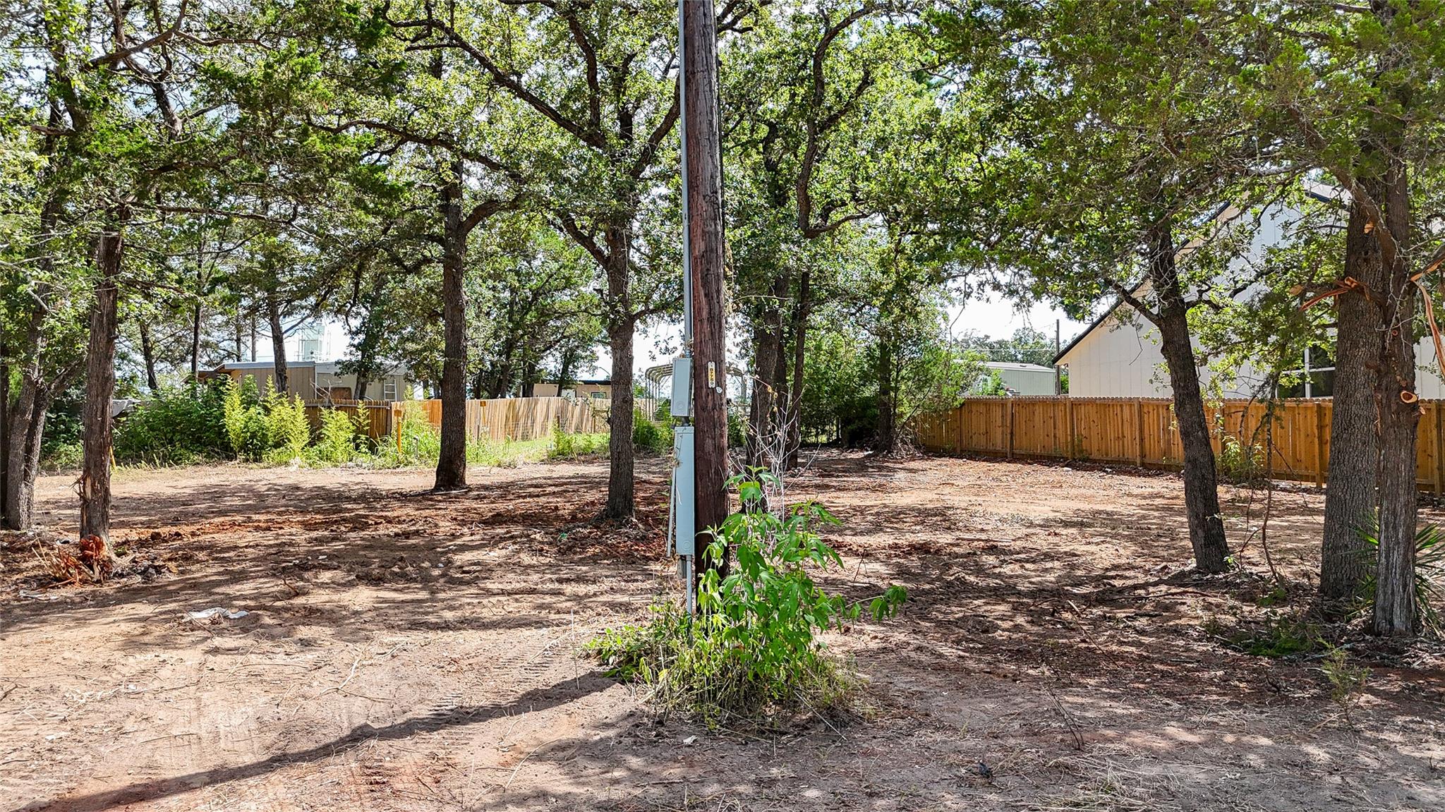 A promising, tree-dotted vacant lot awaits your v