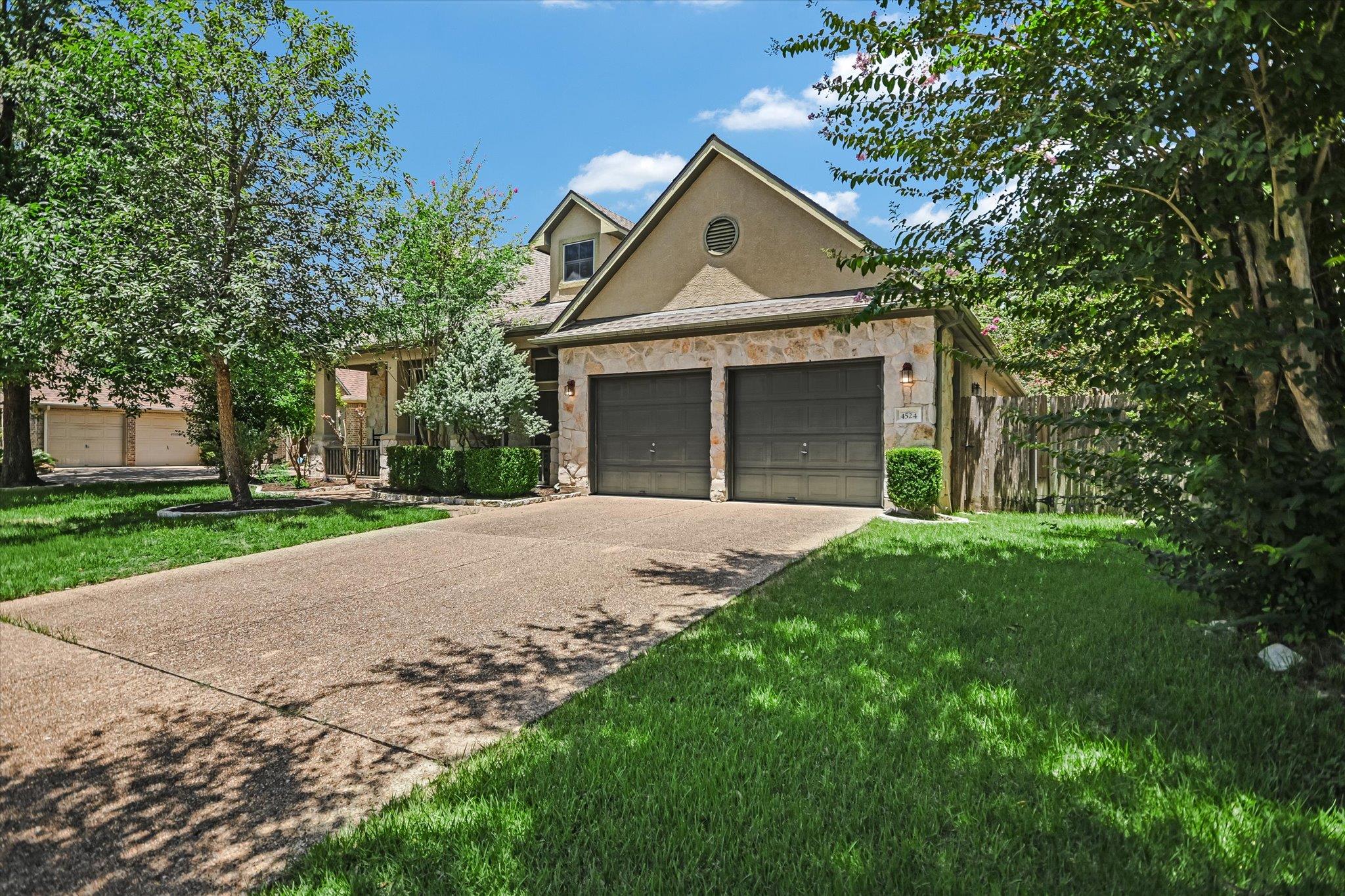 A well-kept front yard and driveway lead to a two