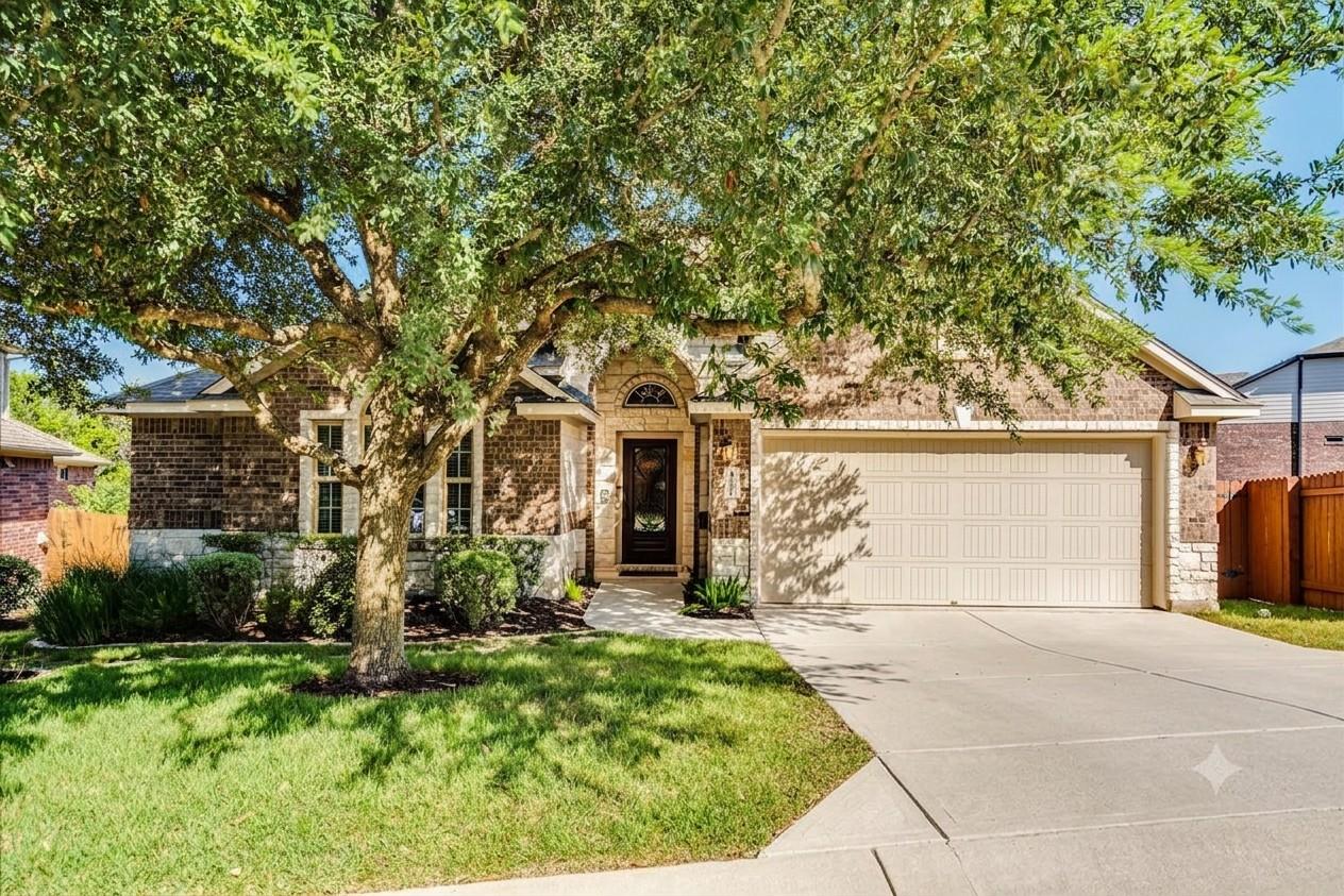 A welcoming brick and stone facade home, shaded b