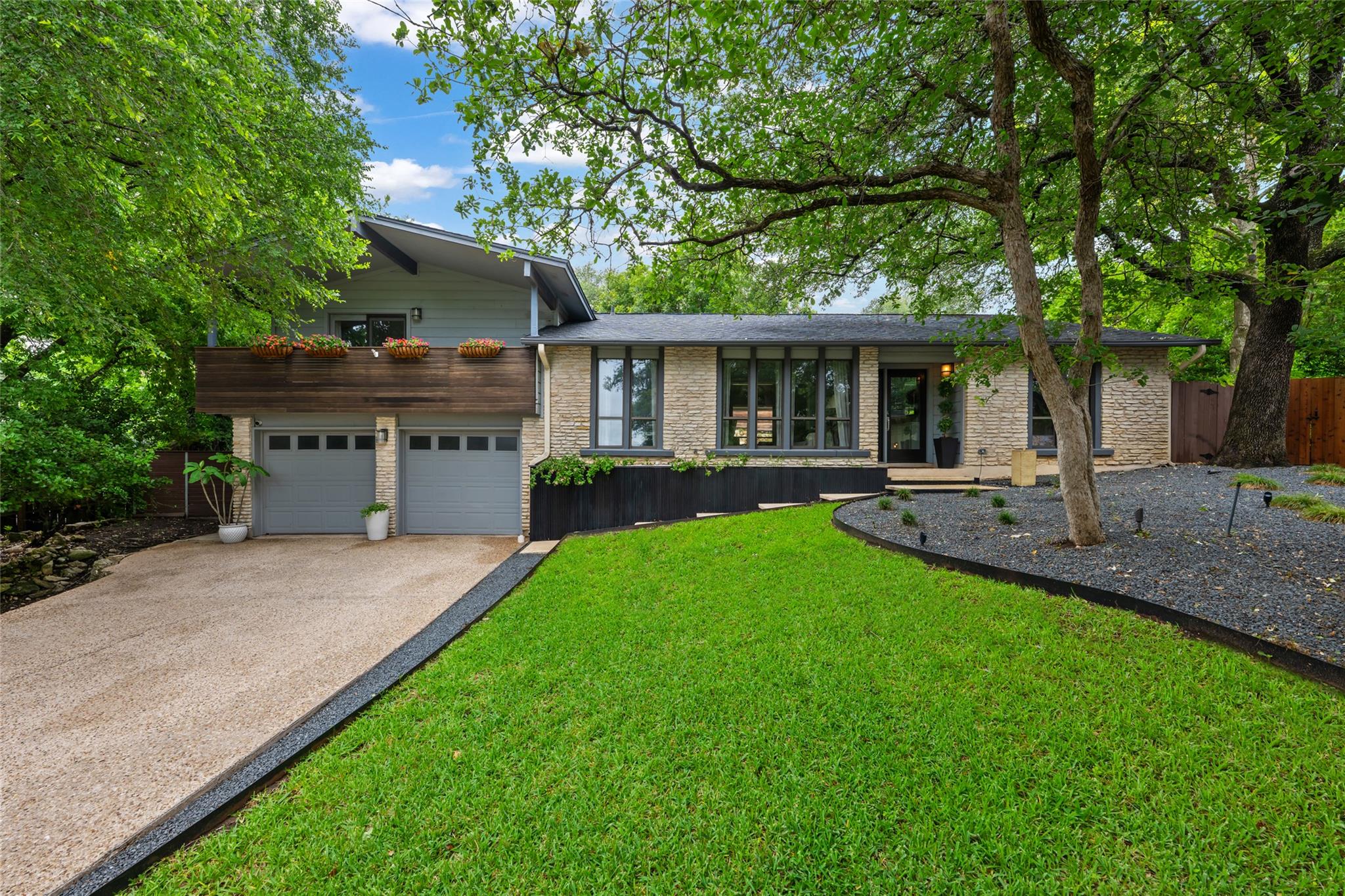 Mature trees canopy this striking home, featuring