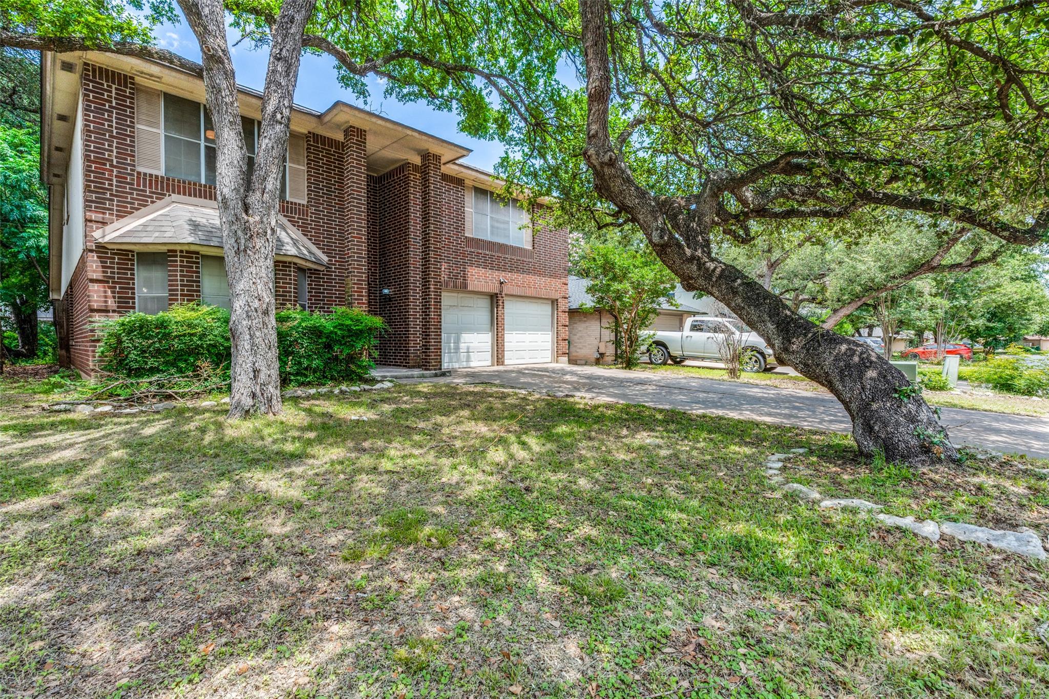 Mature trees shade this brick residence, offering