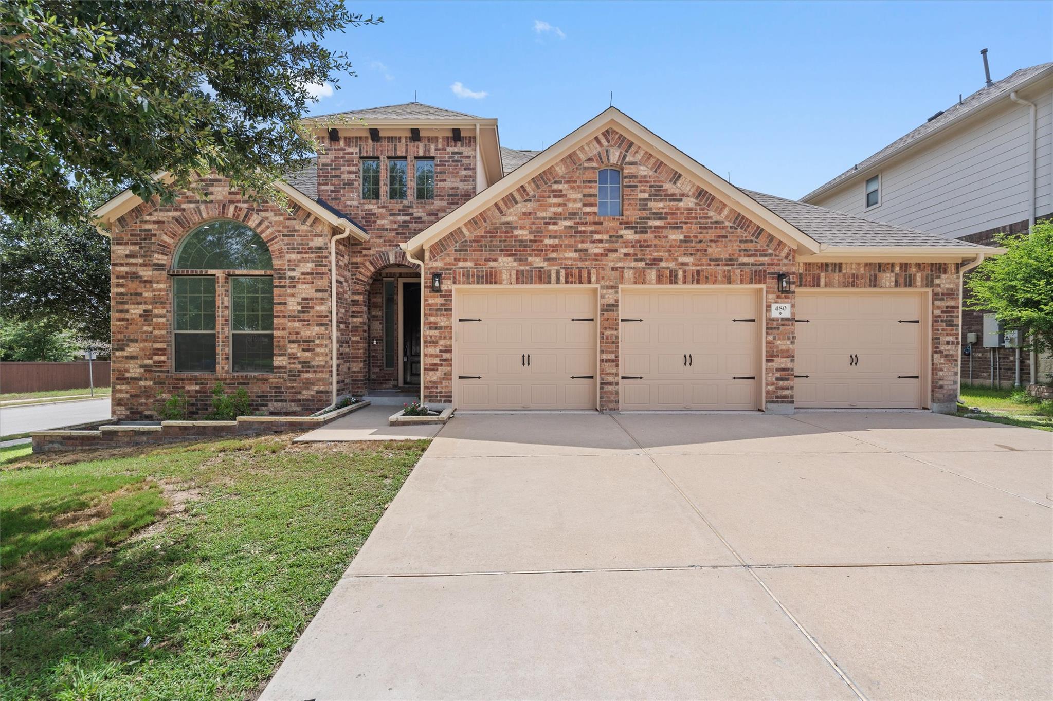 A classic brick exterior and a broad driveway wel