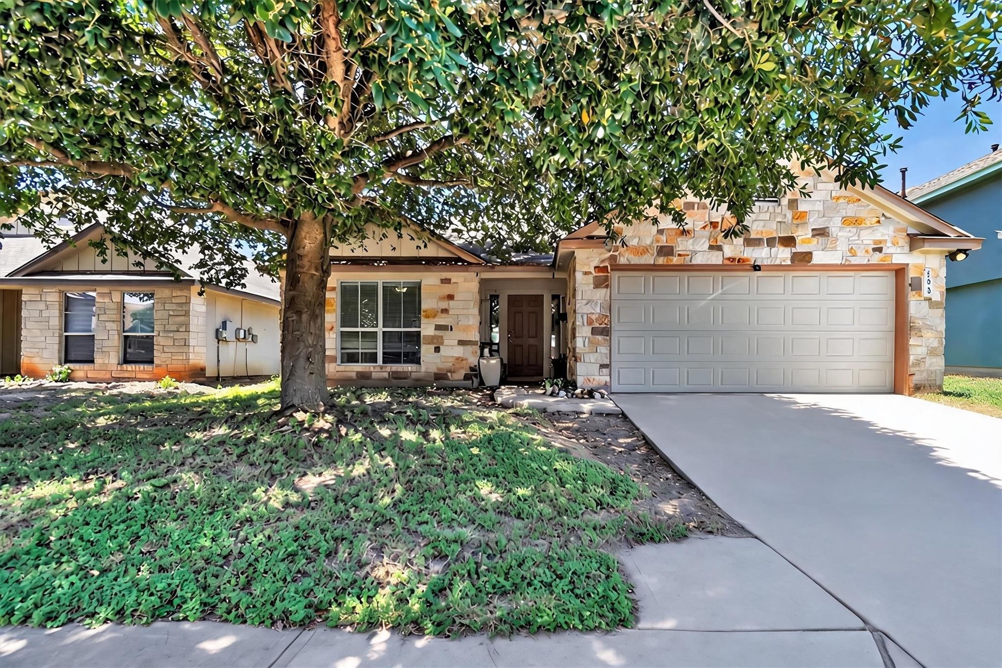 A welcoming stone facade with an attached garage 