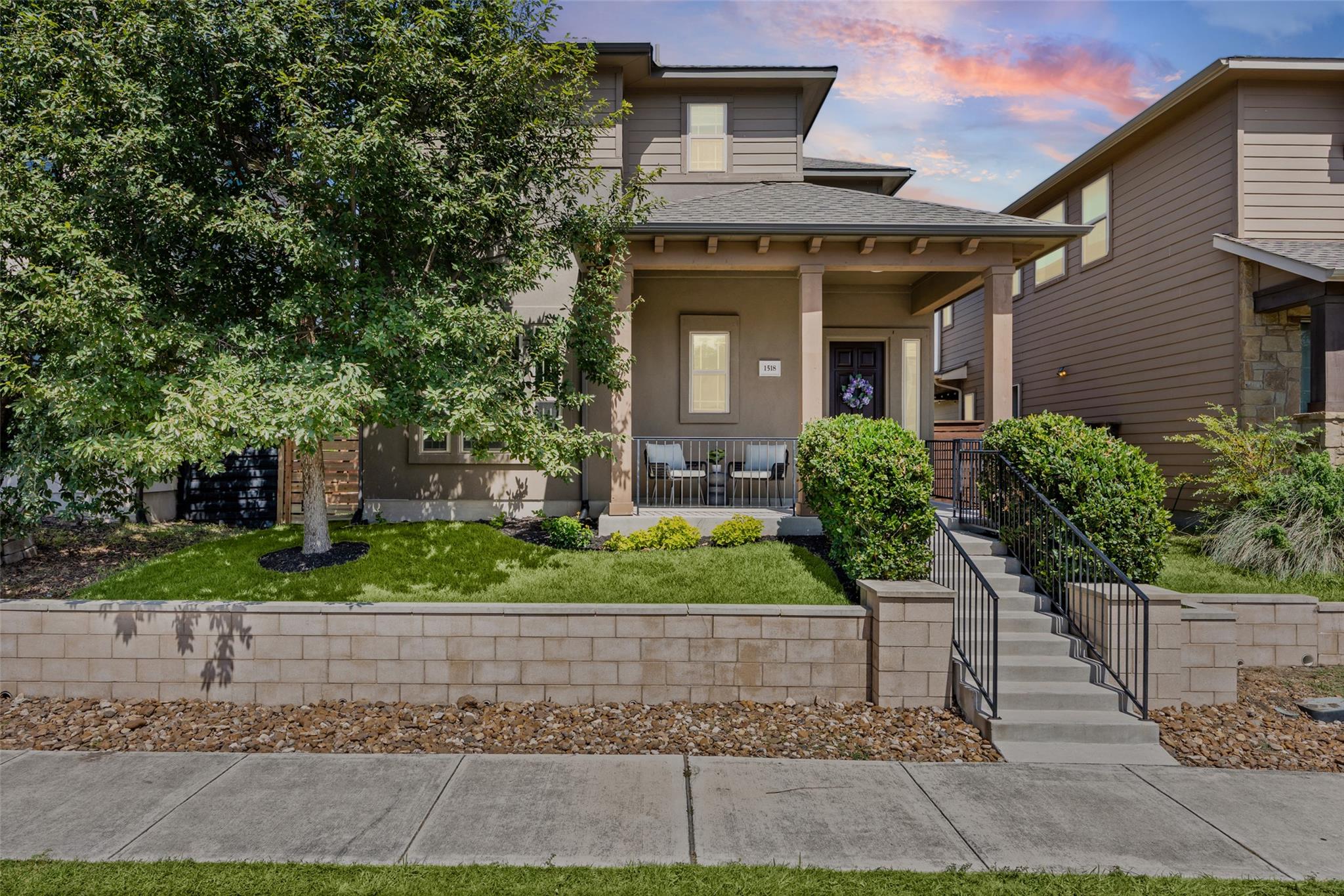 A welcoming front porch with concrete stairs sits