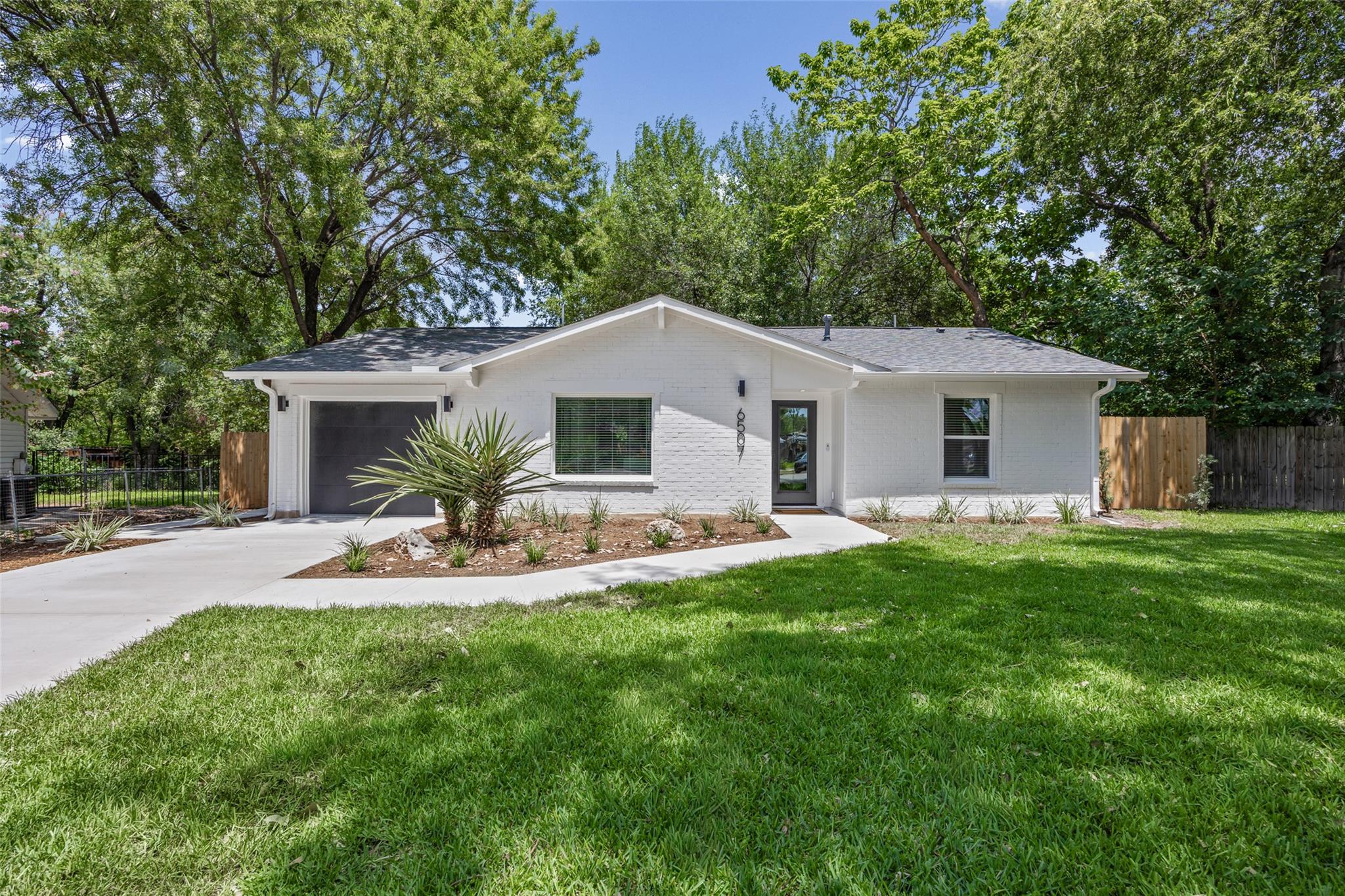 White brick home with a sleek black garage door a