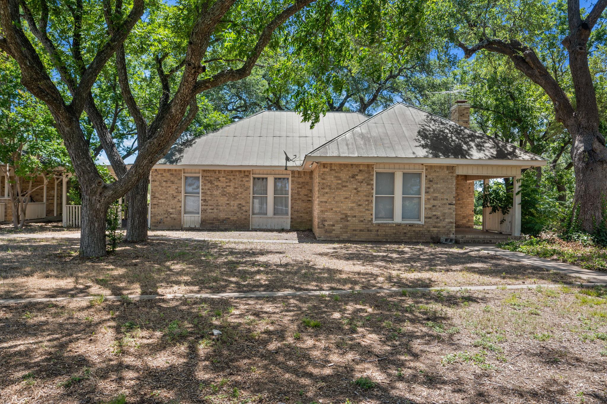 Mature trees shade a charming brick residence, of