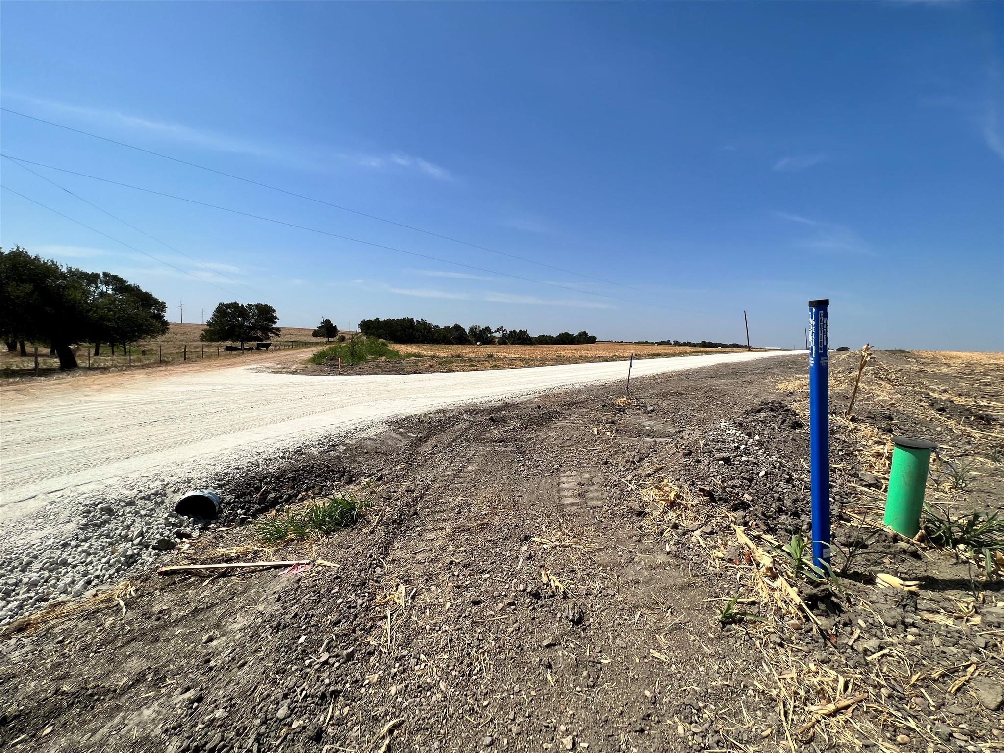 A newly graveled road extends through a rural lan
