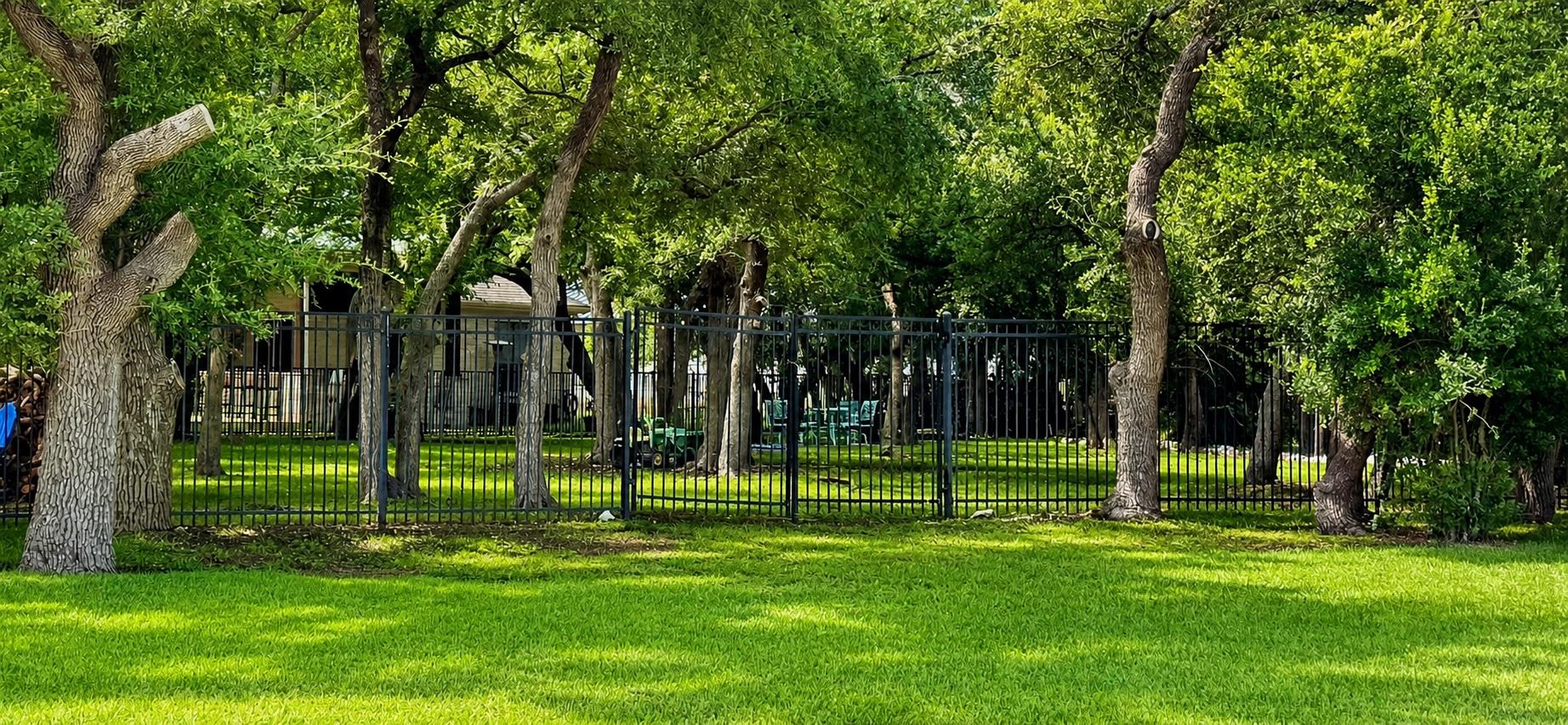 A well-maintained lawn and mature trees are encom
