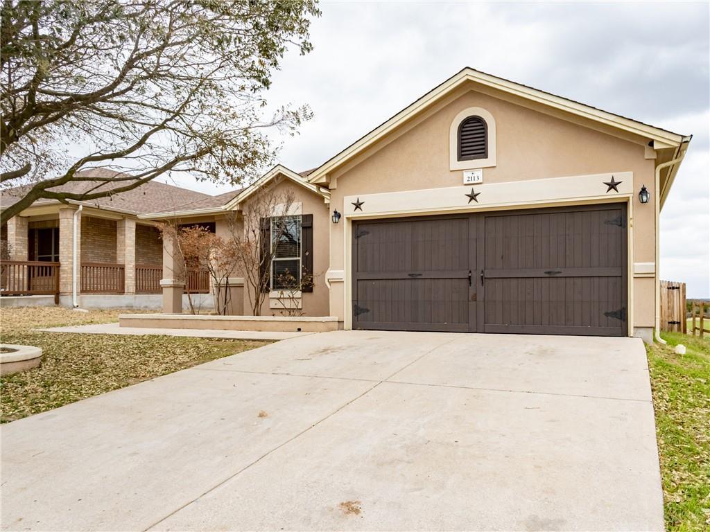 A well-maintained concrete driveway leads to a tw