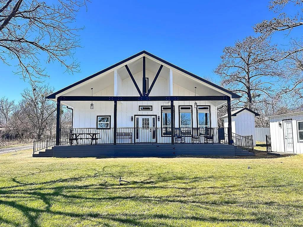 Back of property with a lawn and a porch