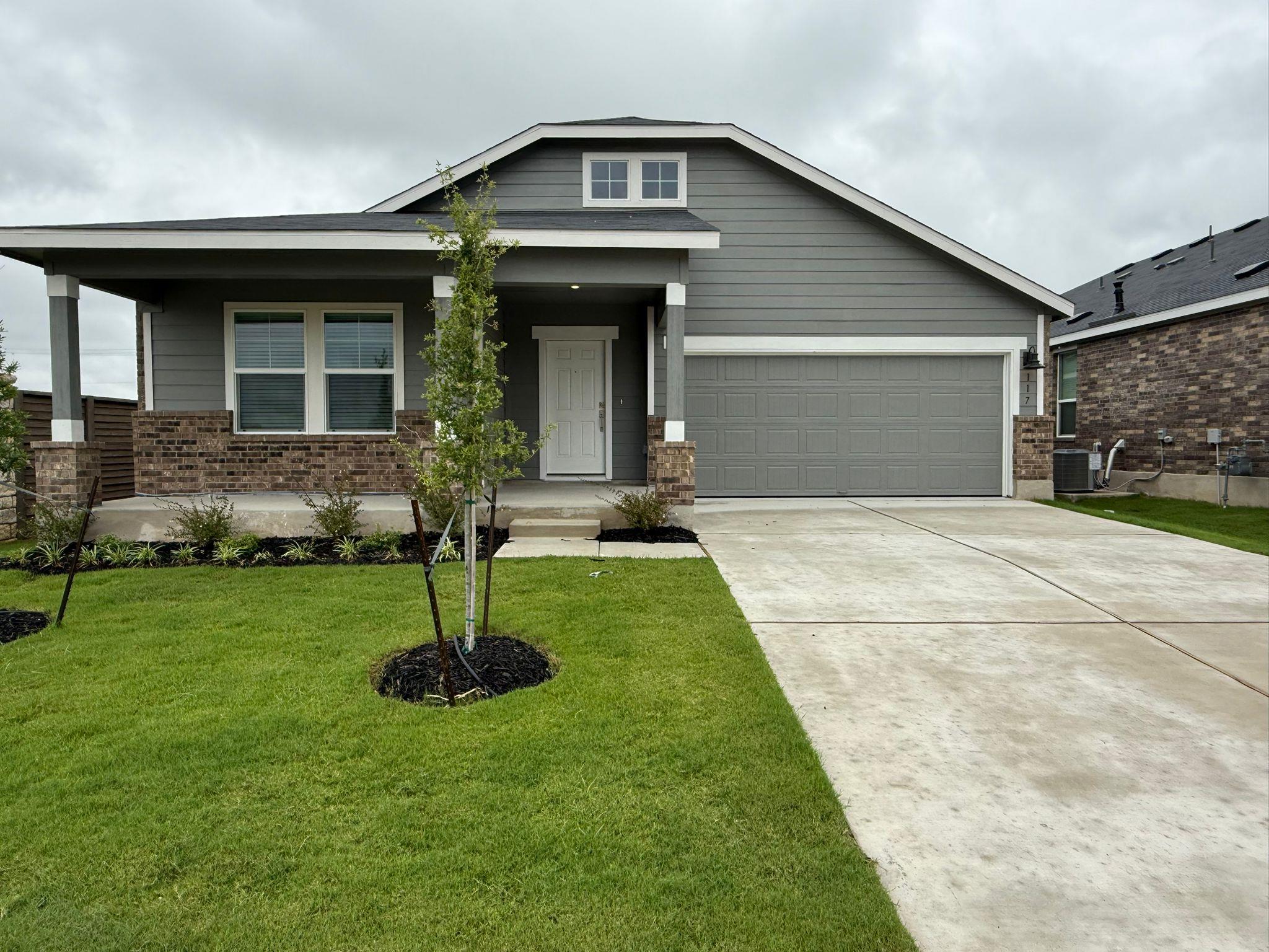 Craftsman-style home with brick siding, driveway,