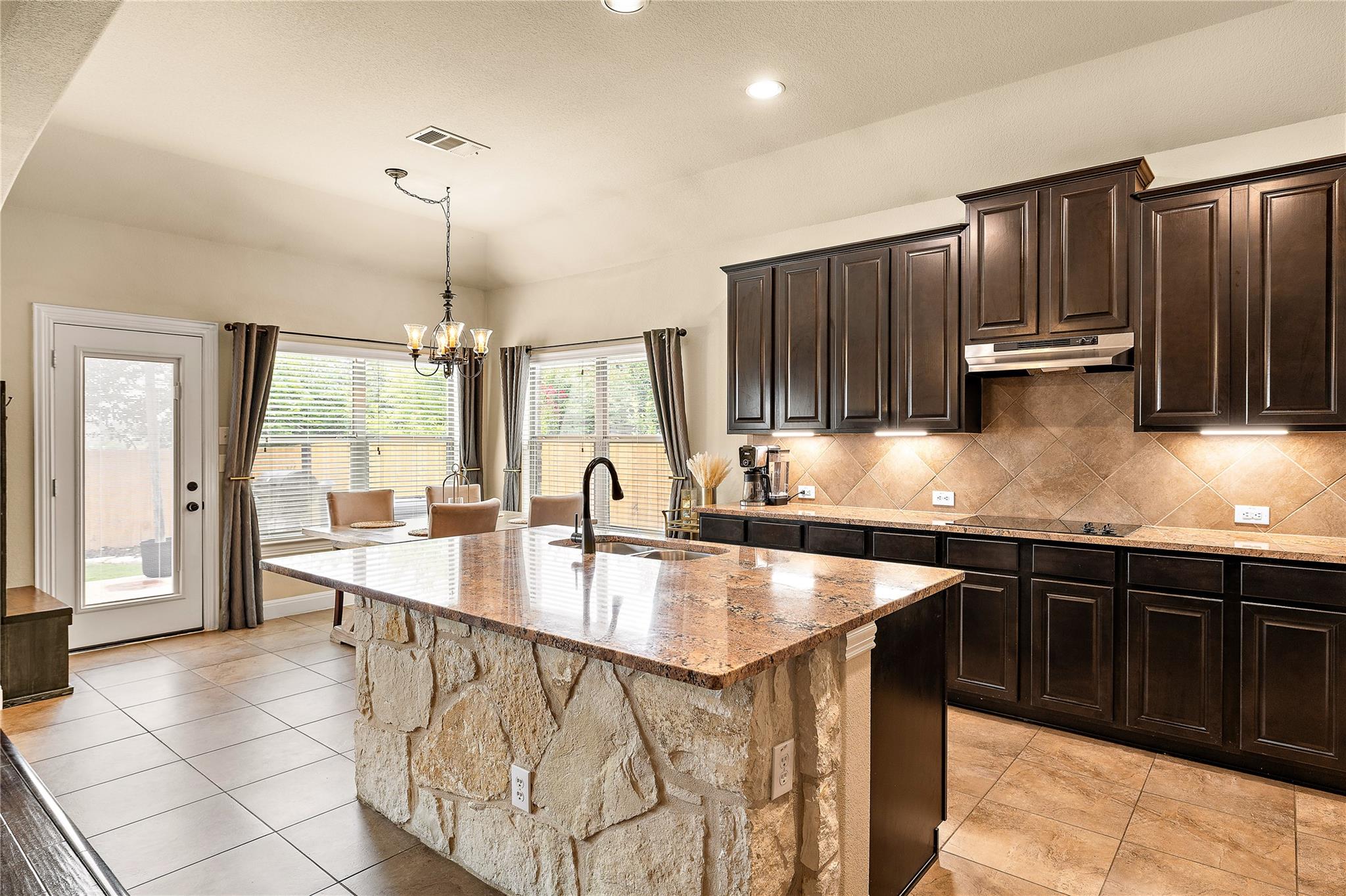 A well-appointed kitchen features a grand stone i