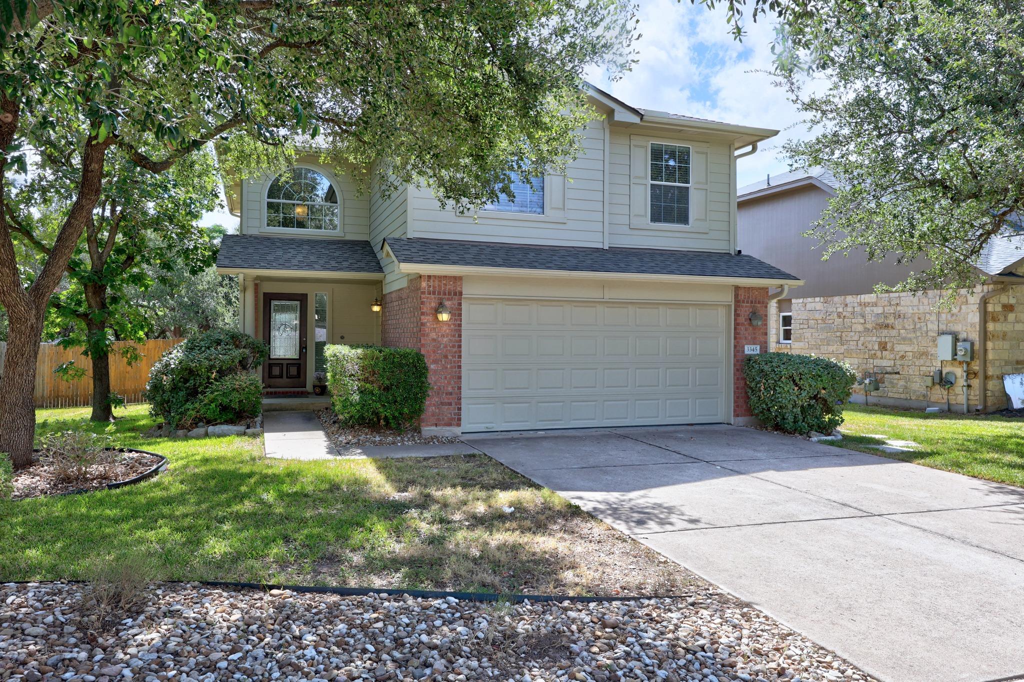 Mature trees shade a classic two-story brick and 