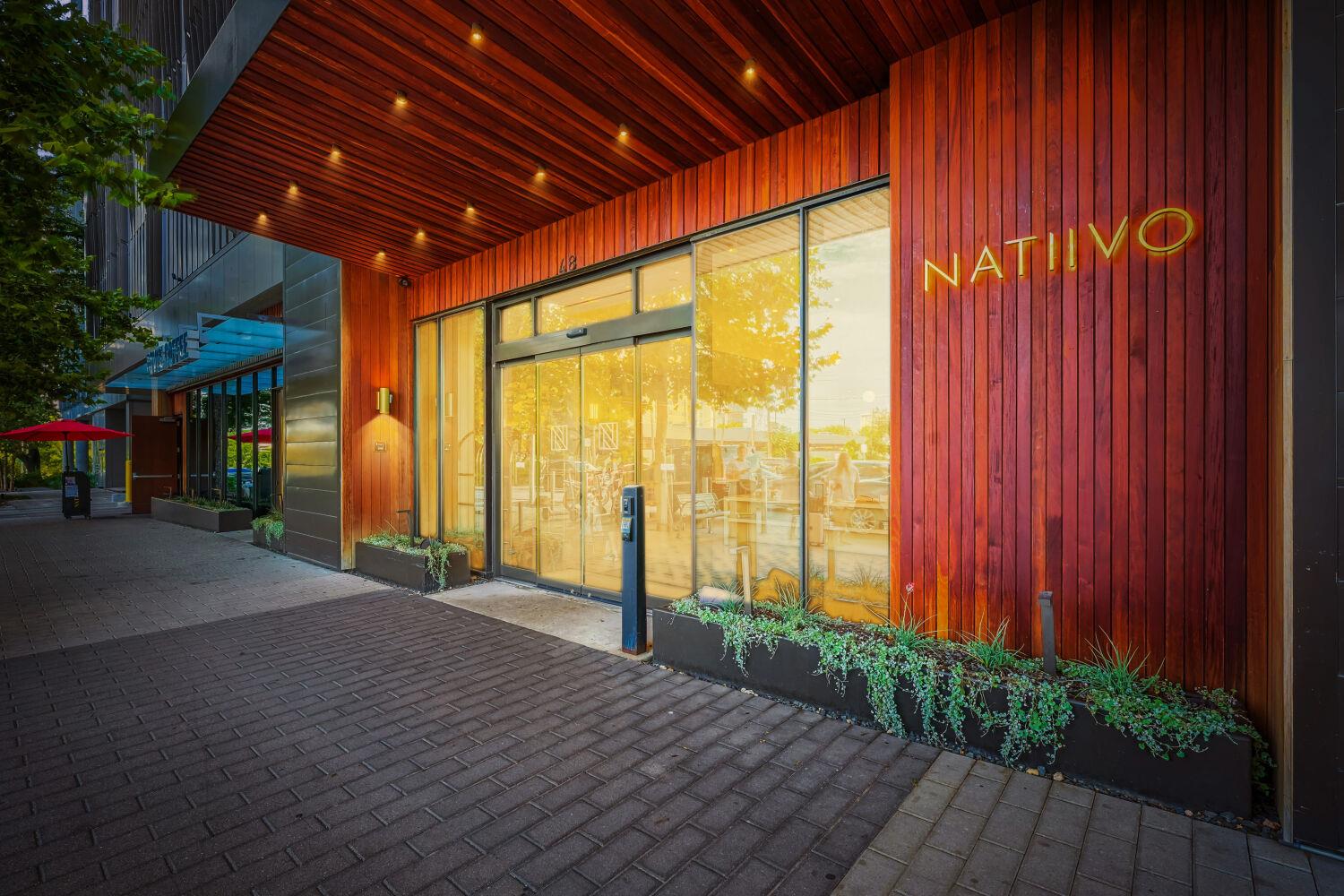 A modern building facade boasts wood siding and l
