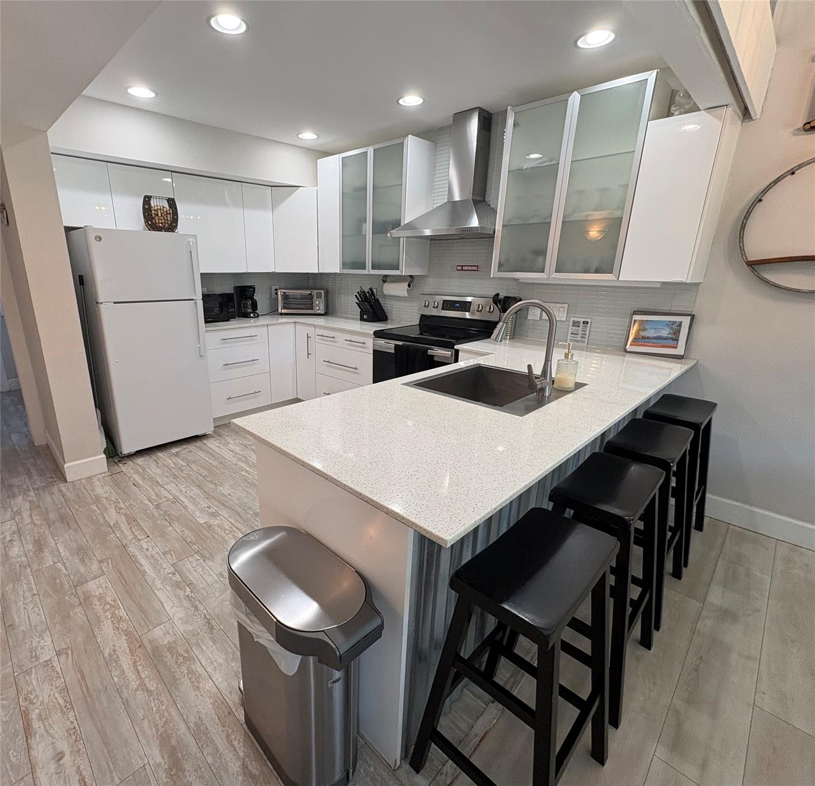 A well-lit kitchen with sleek white cabinetry and