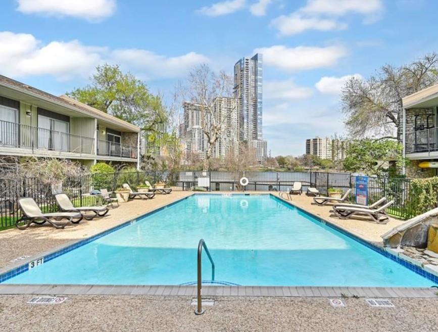 Pool with a city view, a water slide, a patio, an
