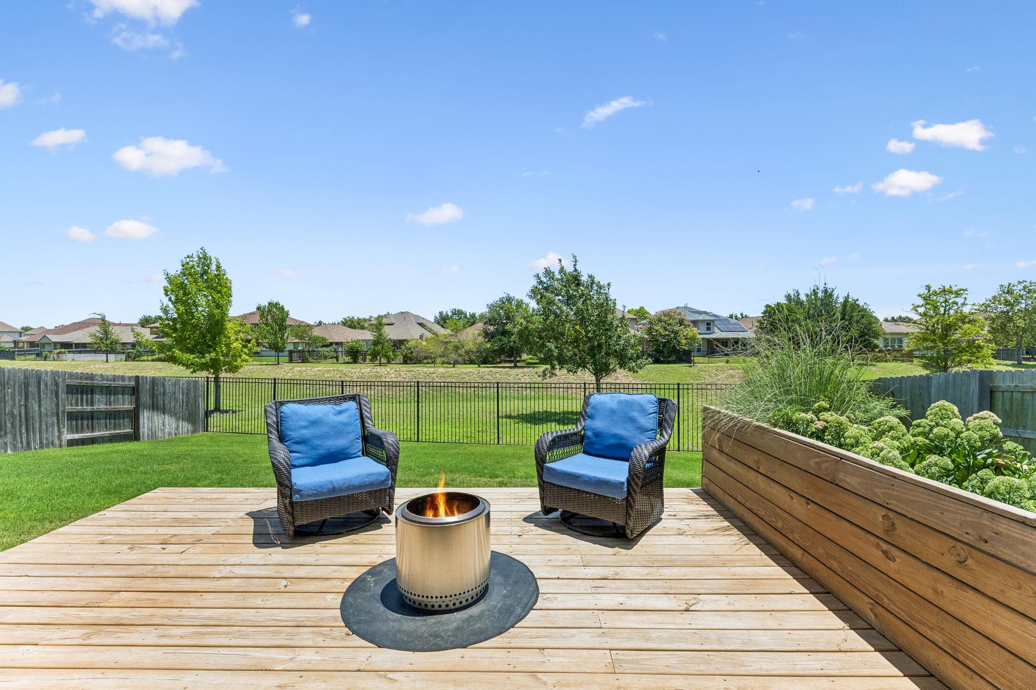 A welcoming backyard deck with a fire pit offers 
