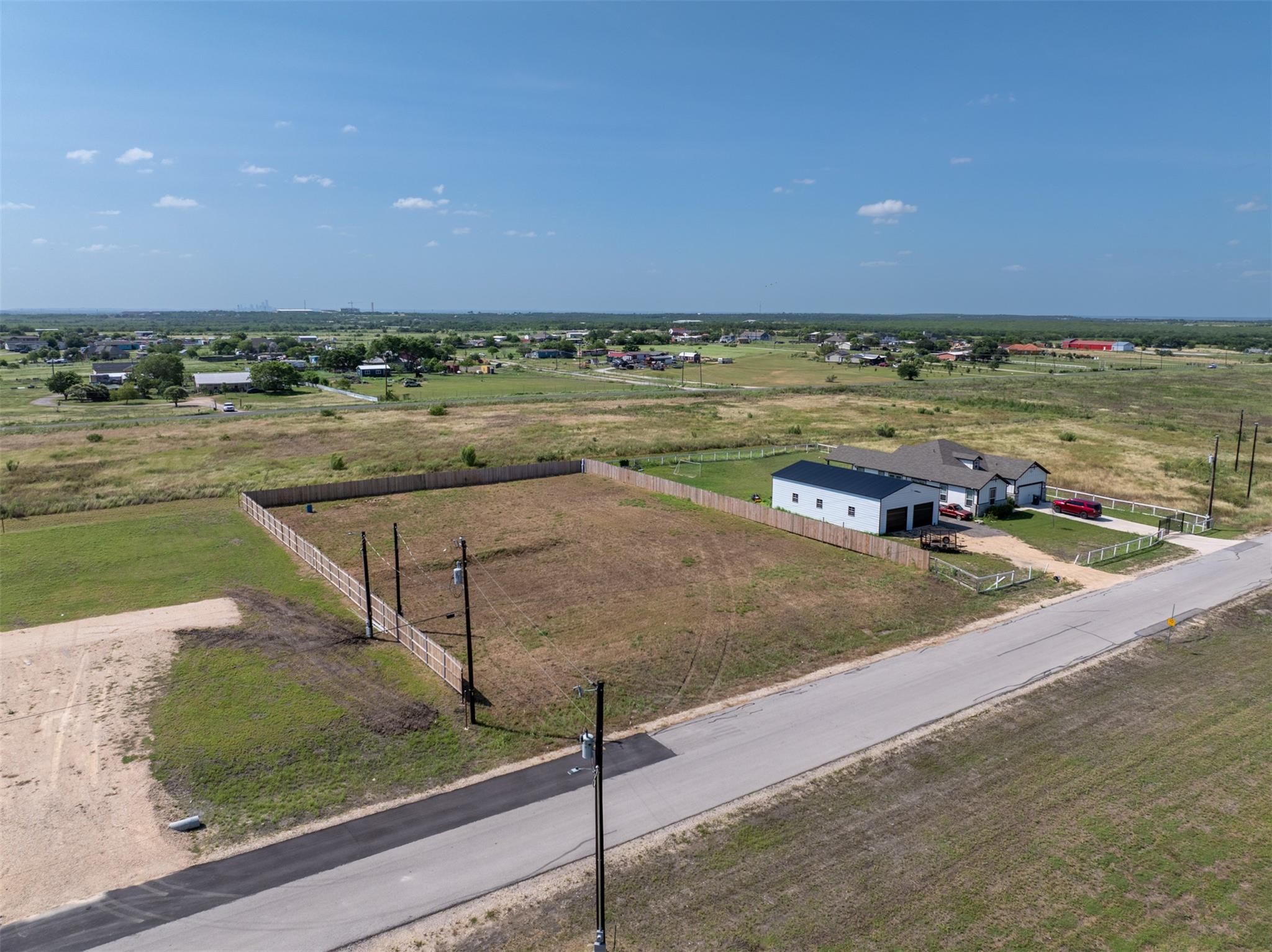 A spacious lot featuring a white farmhouse with a