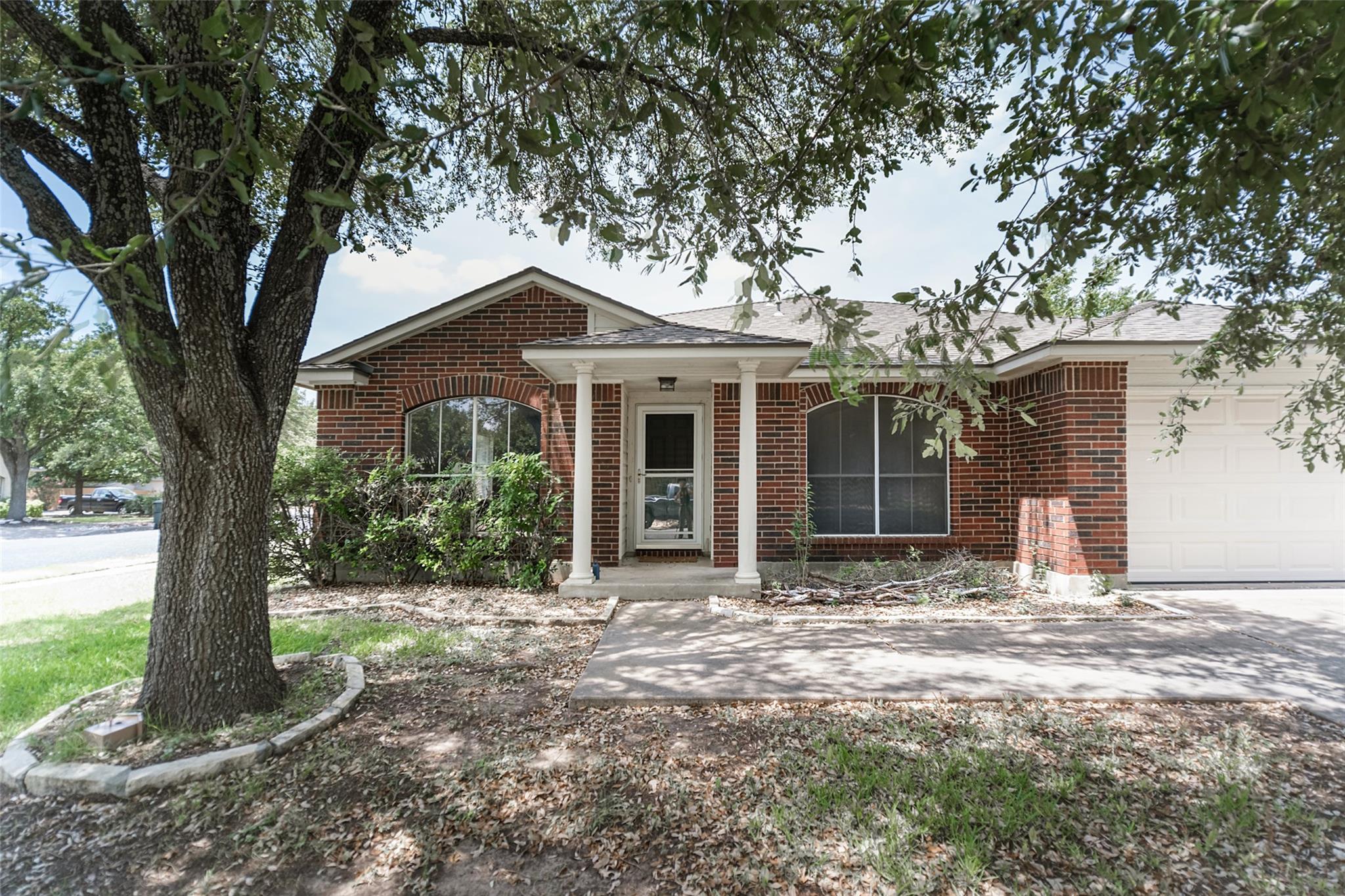 Brick facade with a welcoming porch and attached 