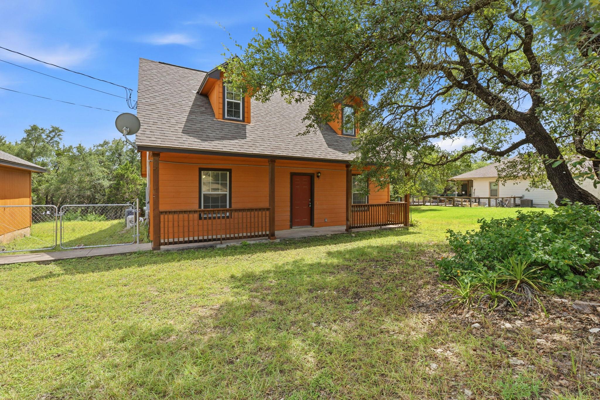 A welcoming front porch and mature trees define t