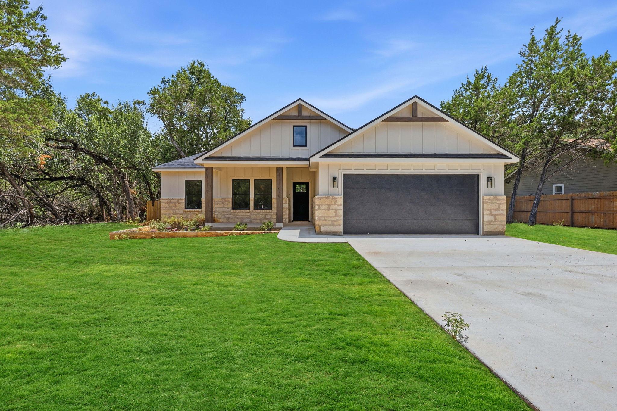 A well-maintained lawn and stone facade enhance t