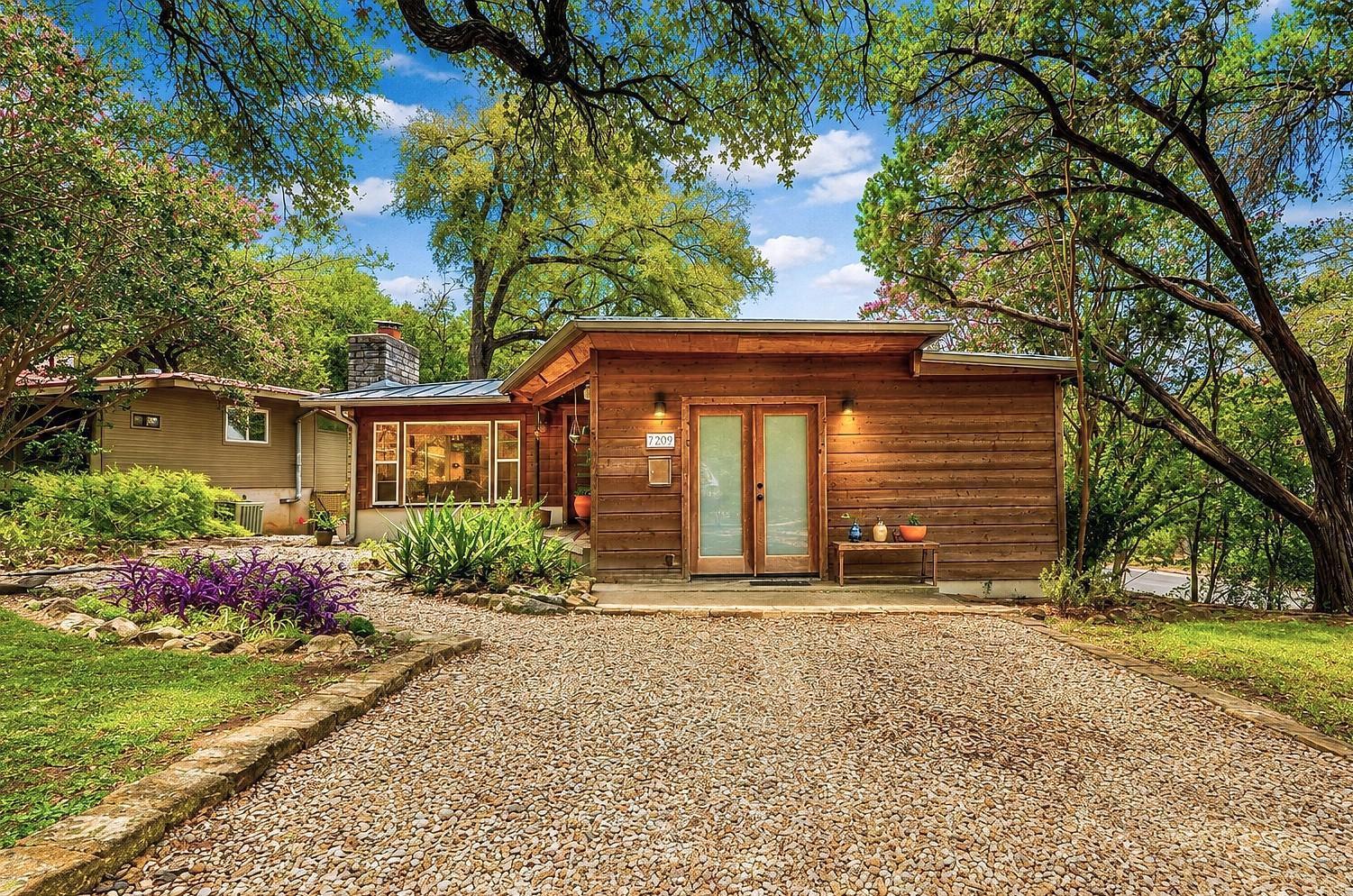 A charming wooden-sided home nestled amidst lush 