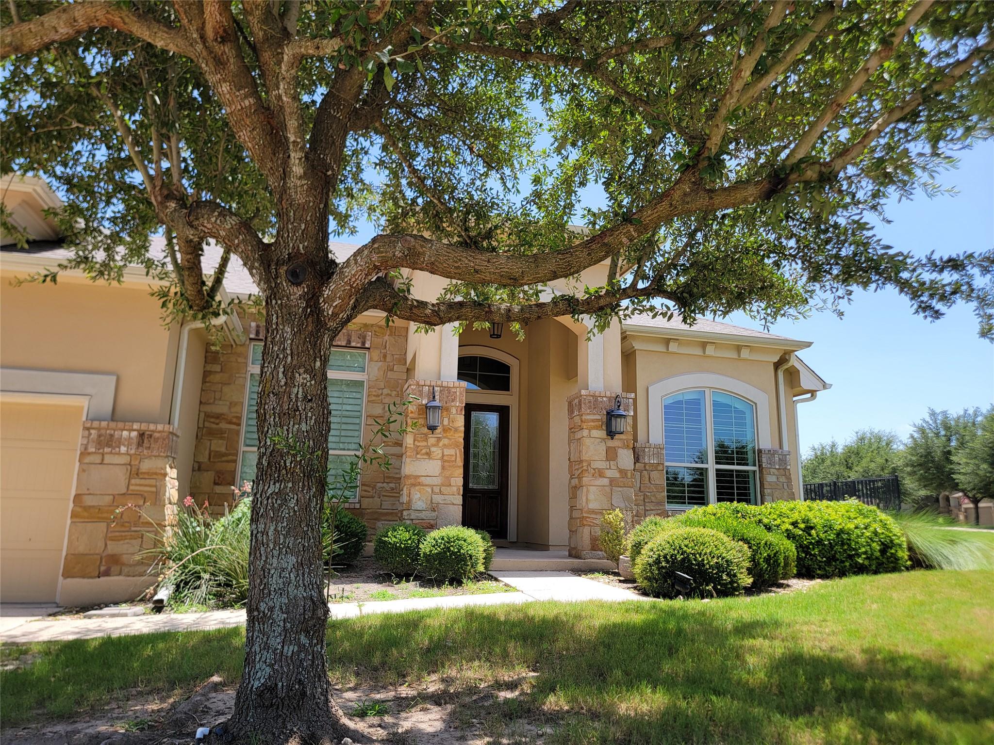A welcoming stone and stucco facade frames the ma