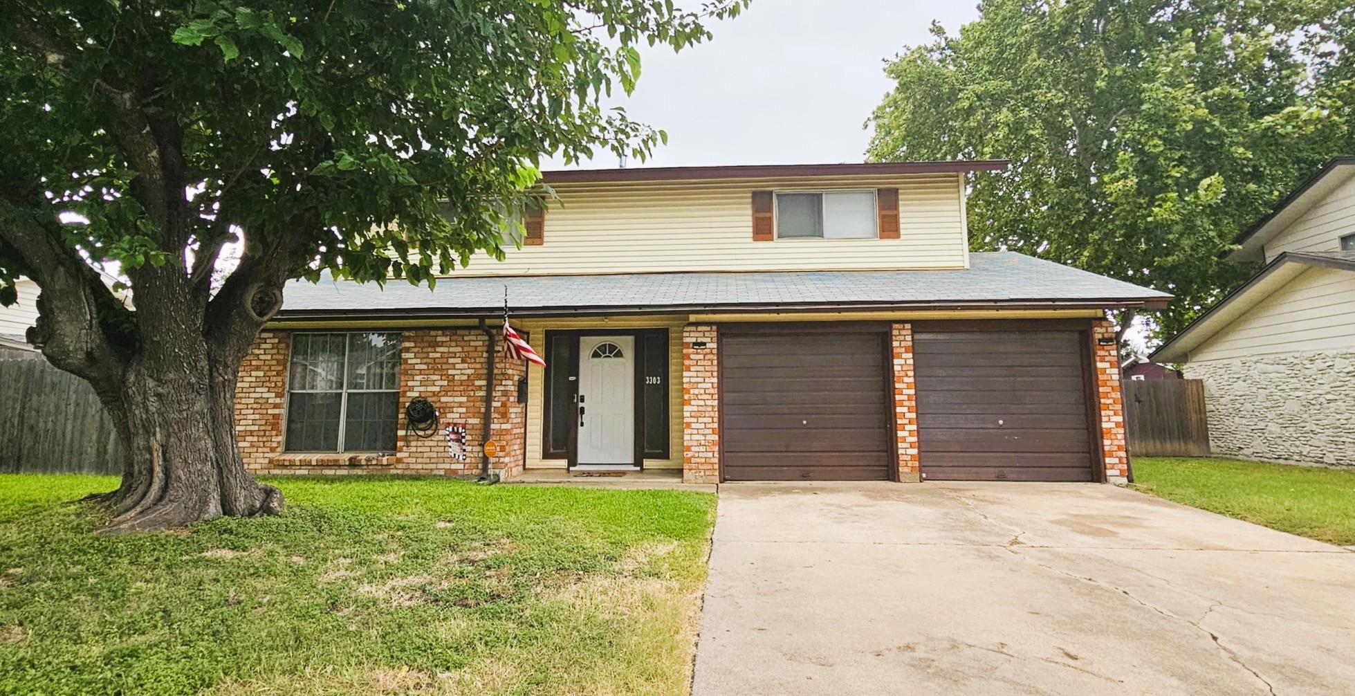 A classic brick and siding home presents a welcom