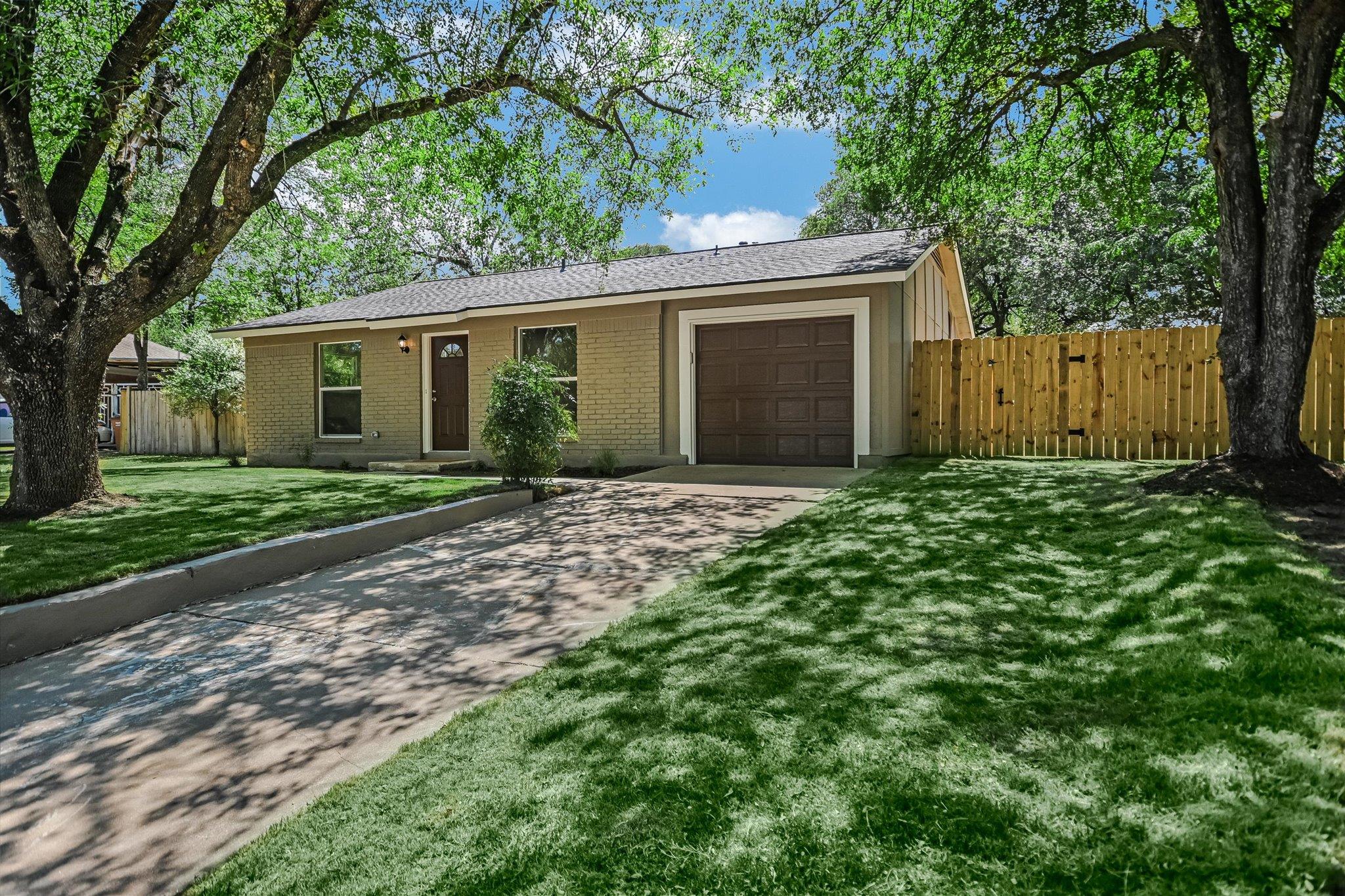 Mature trees shade this single-story home, featur