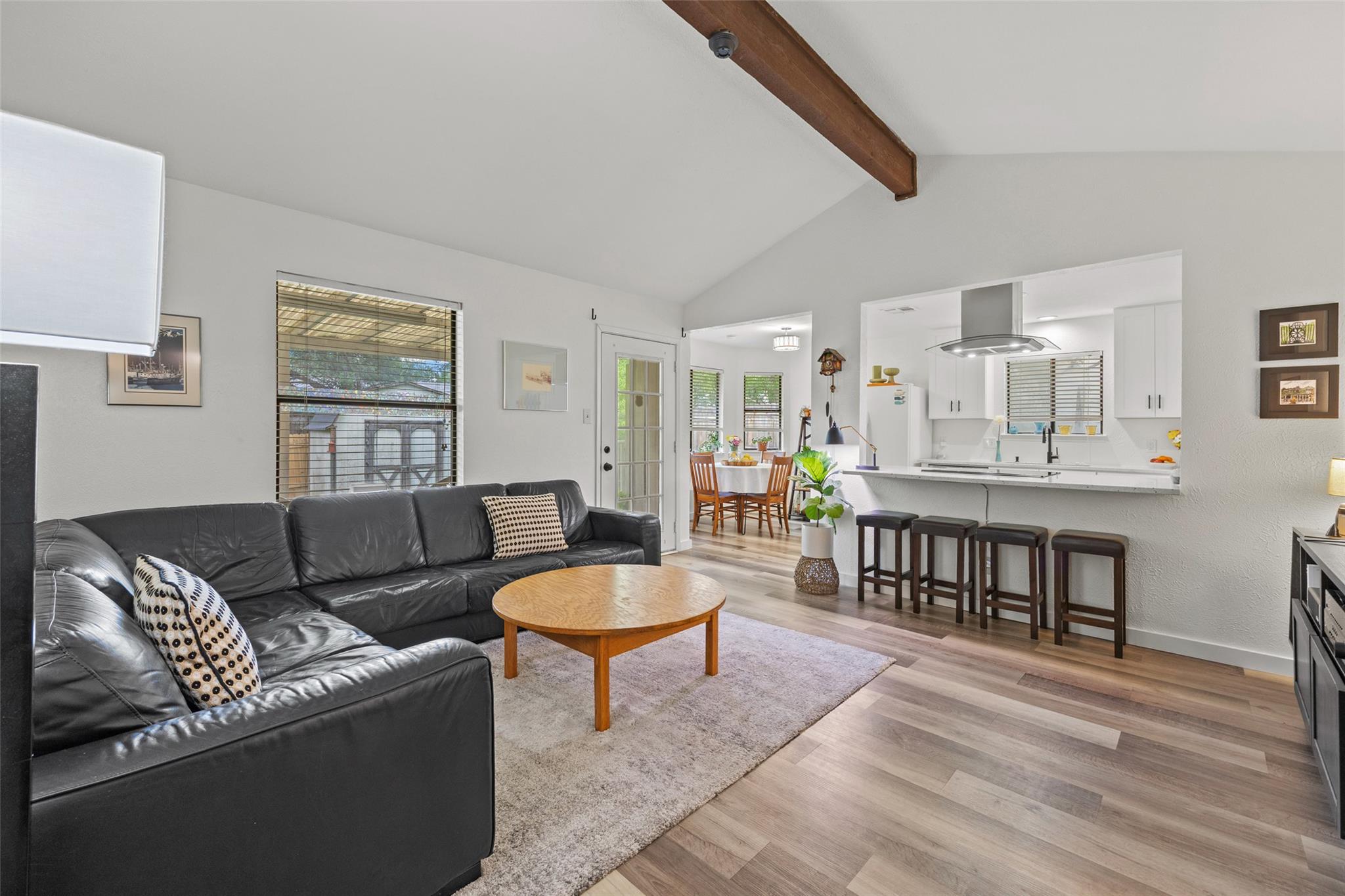 A wooden beam accents the vaulted ceiling in this