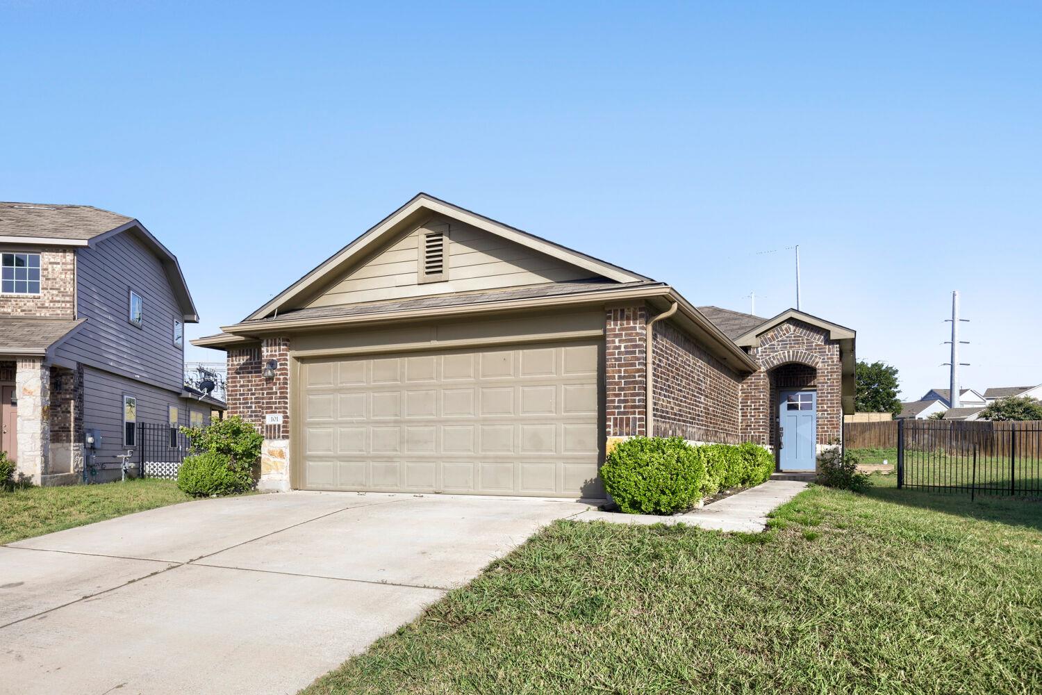 A well-kept front yard and brick facade enhance t