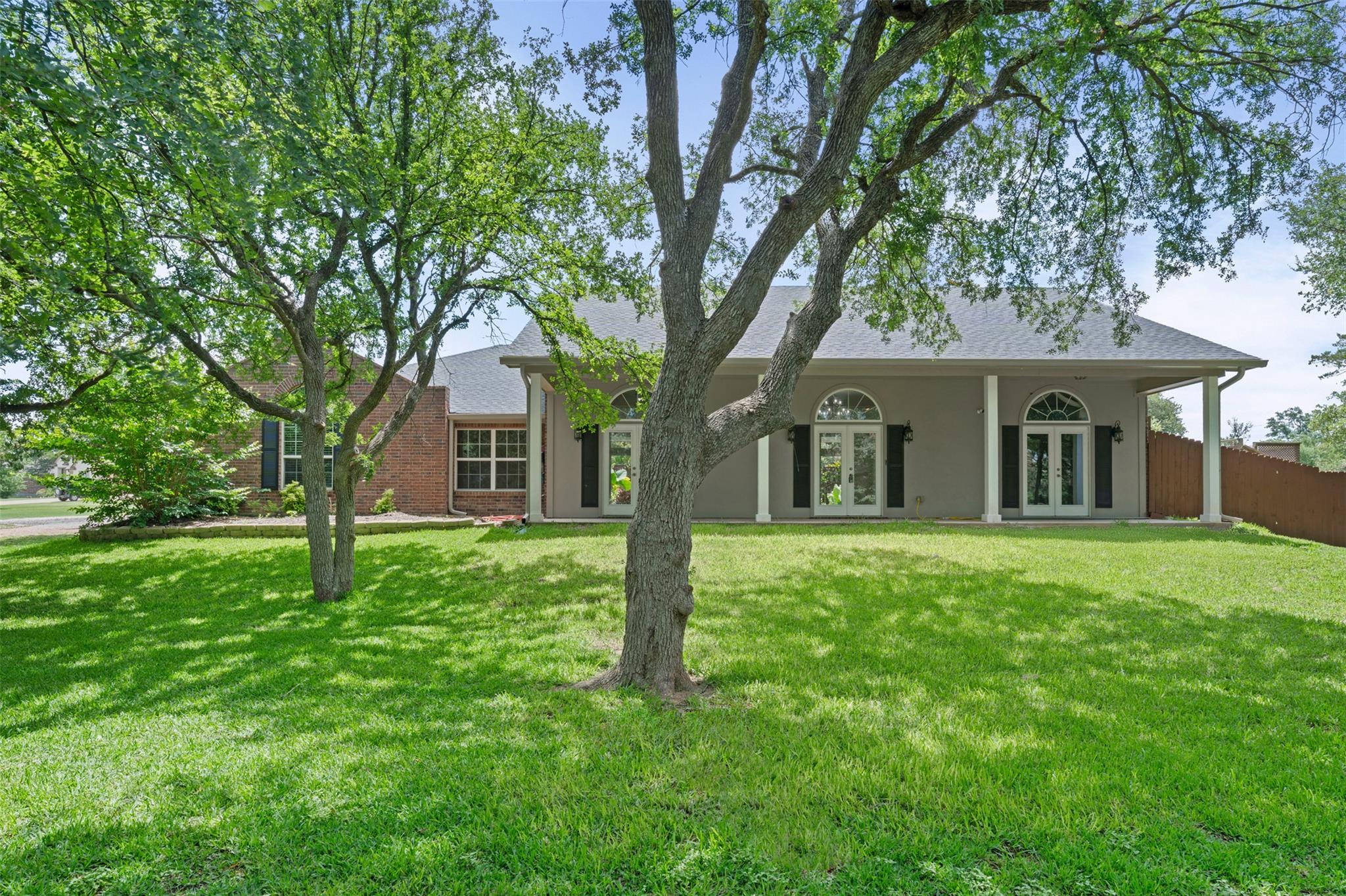 Mature trees frame the verdant lawn leading up to