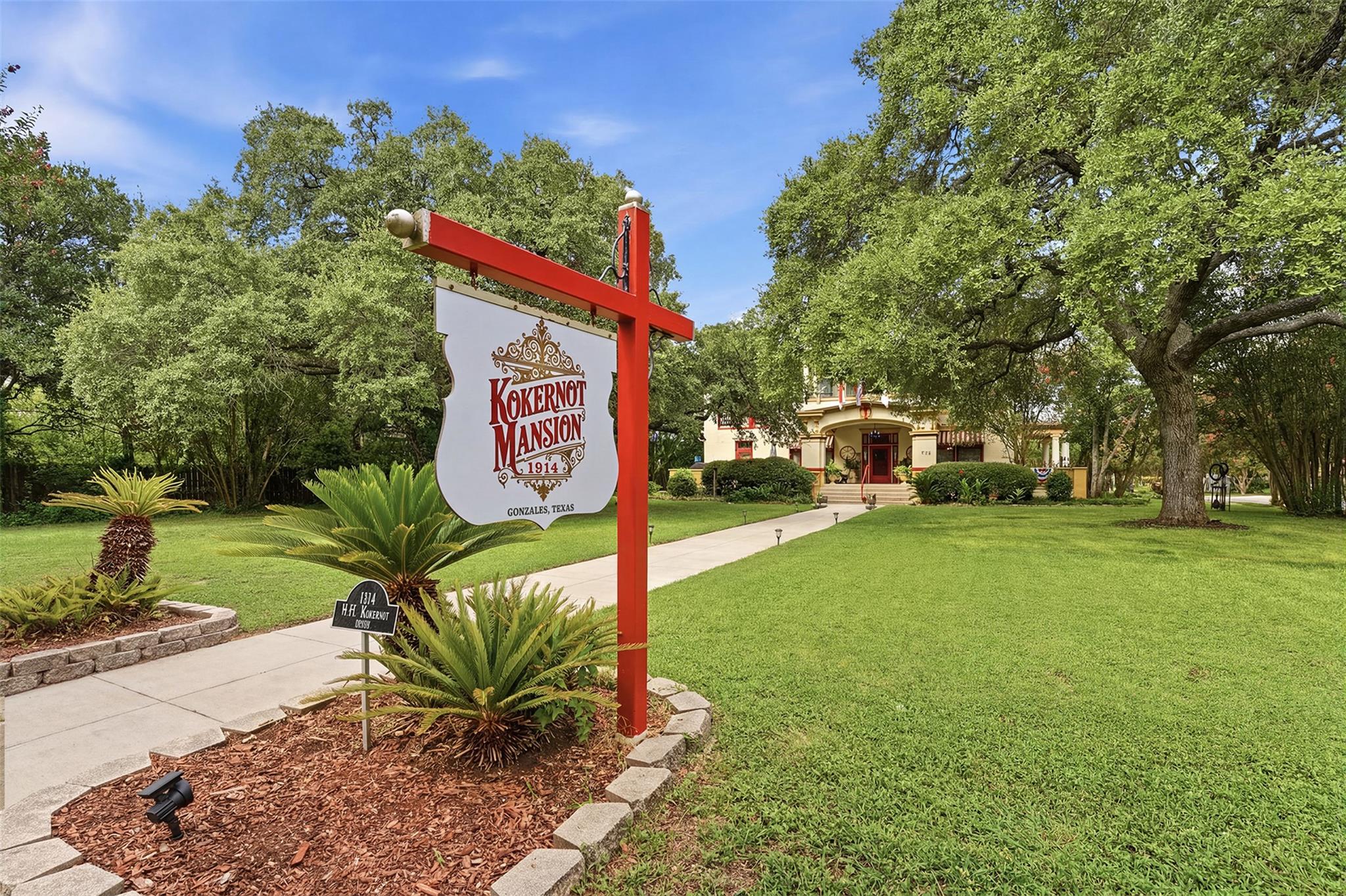 A grand estate with sprawling lawns and mature tr