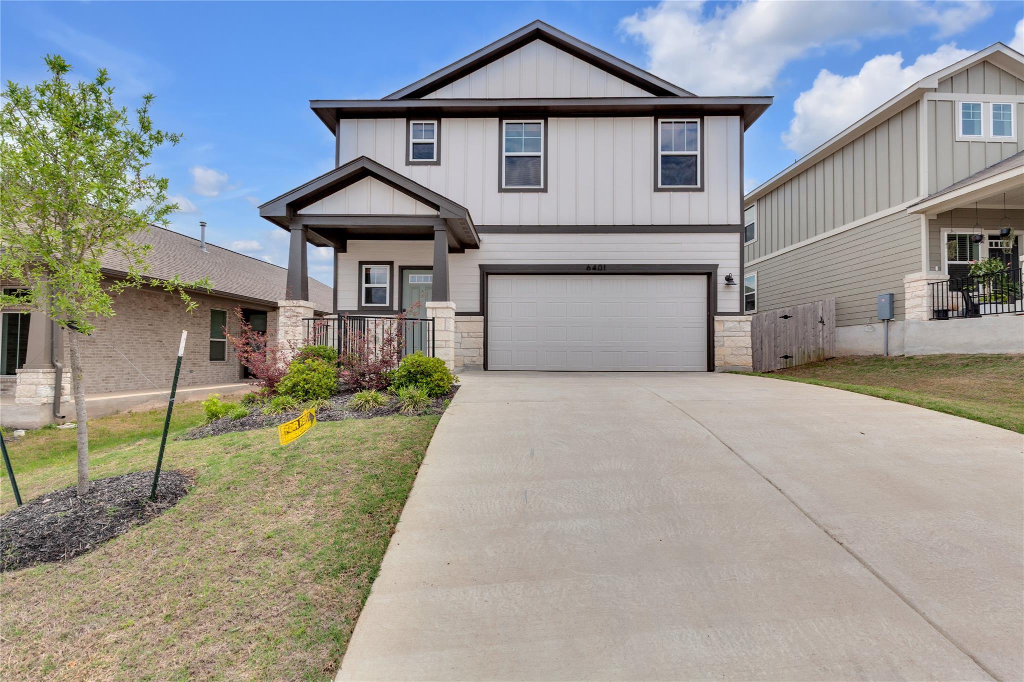 Craftsman house featuring stone siding, driveway,