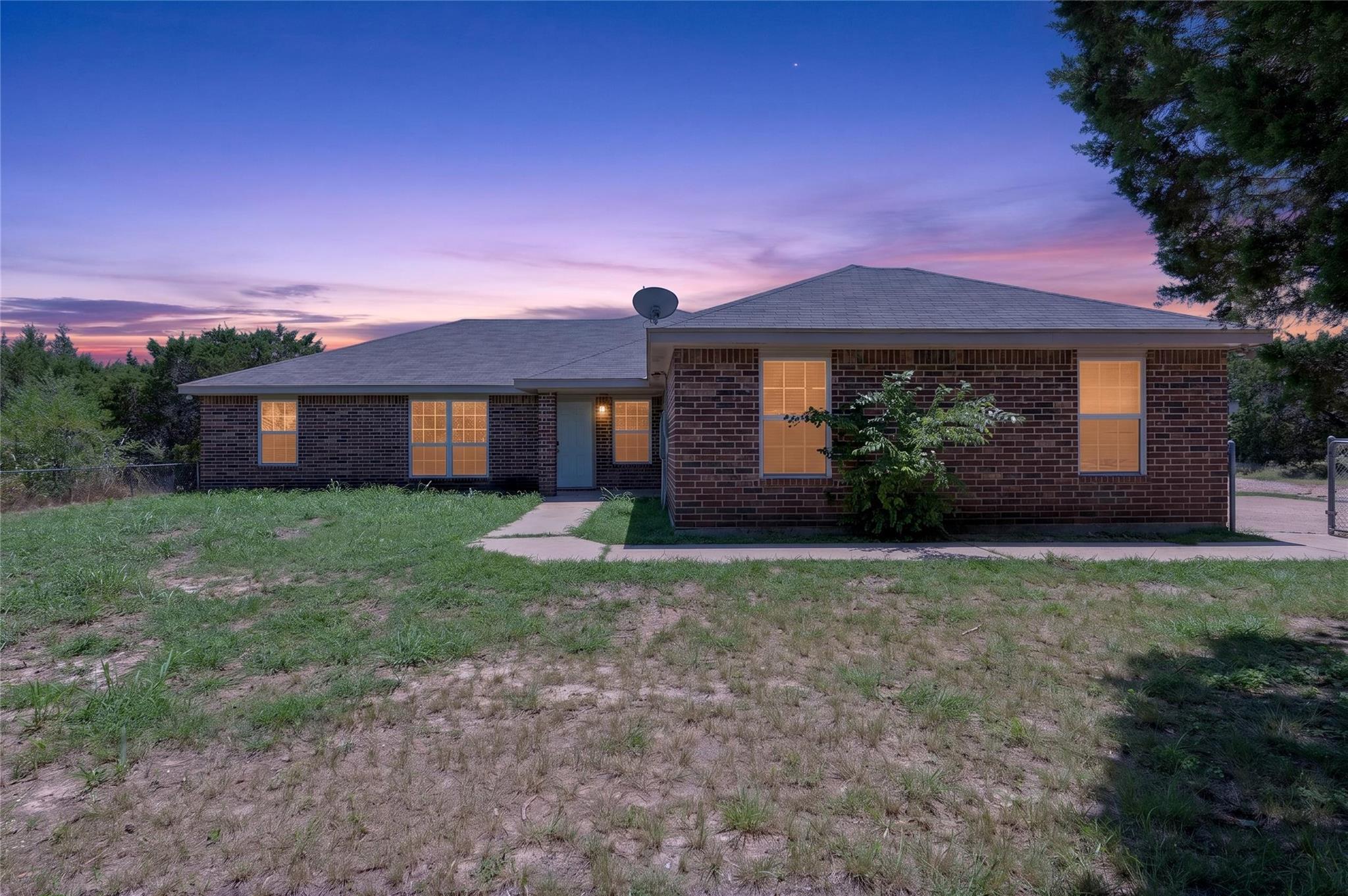 Brick facade home set against a vibrant sunset sk