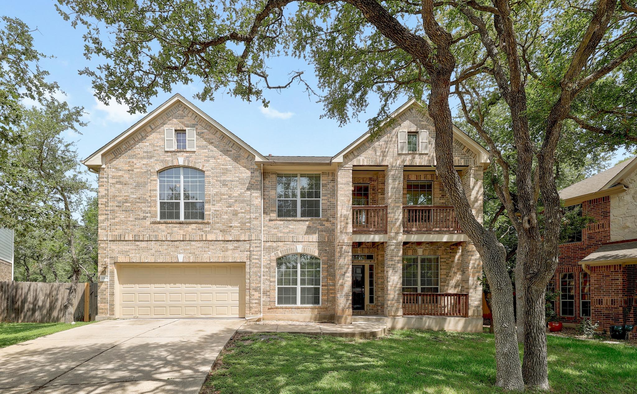 Two-story brick residence with dual balconies and