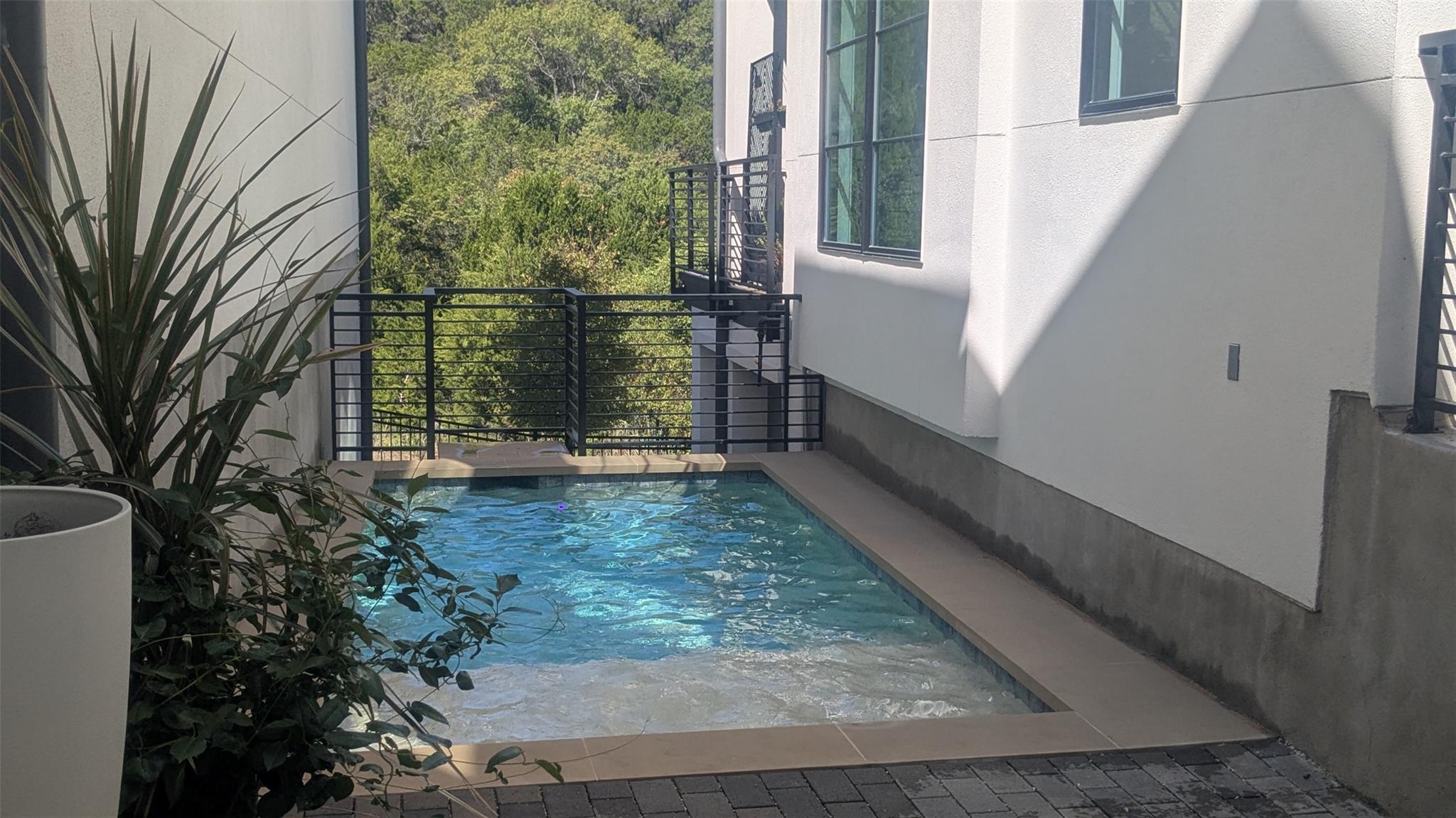 An intimate plunge pool rests alongside smooth st